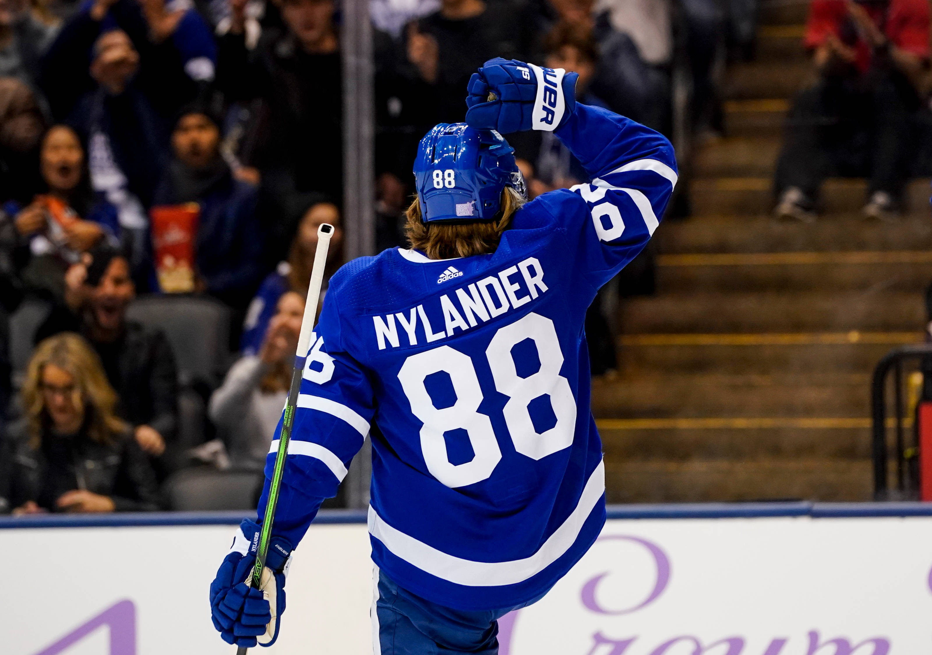 hockey 桌布 壁紙 — 身穿藍色88號球衣的冰球運動員Nylander在場館得分後向人群舉起戴手套的手。