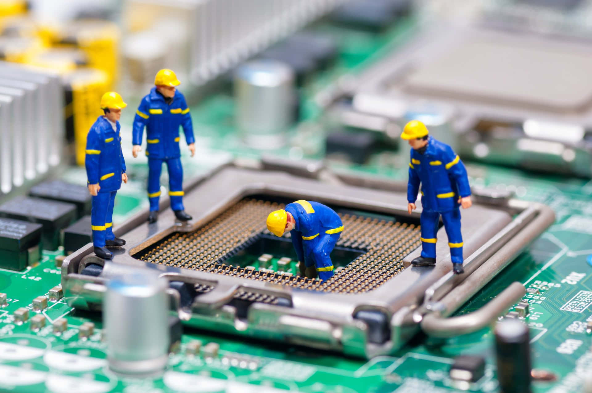 Electronics 桌布 壁紙 — 身穿藍色制服和黃色安全帽的小型建築工人站在綠色電路板上檢查CPU插座。