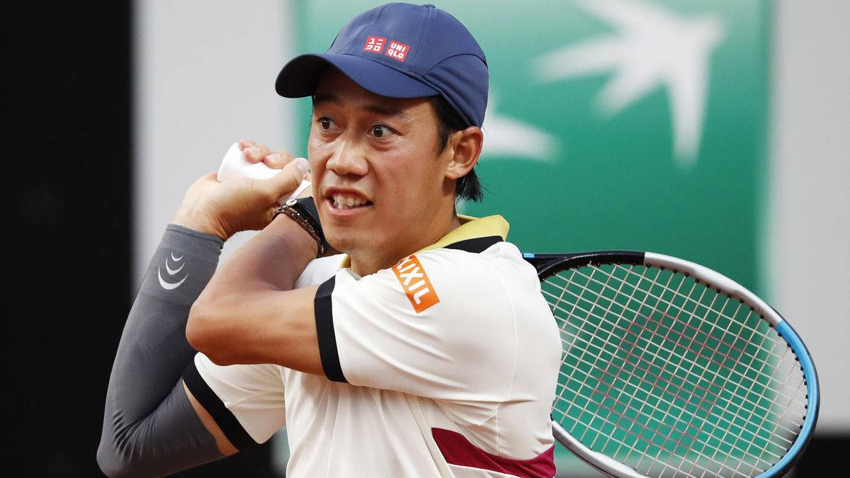 Wilson 桌布 壁紙 — 身穿藍色帽子和白色襯衫的網球選手在紅土球場比賽中專注地揮拍。