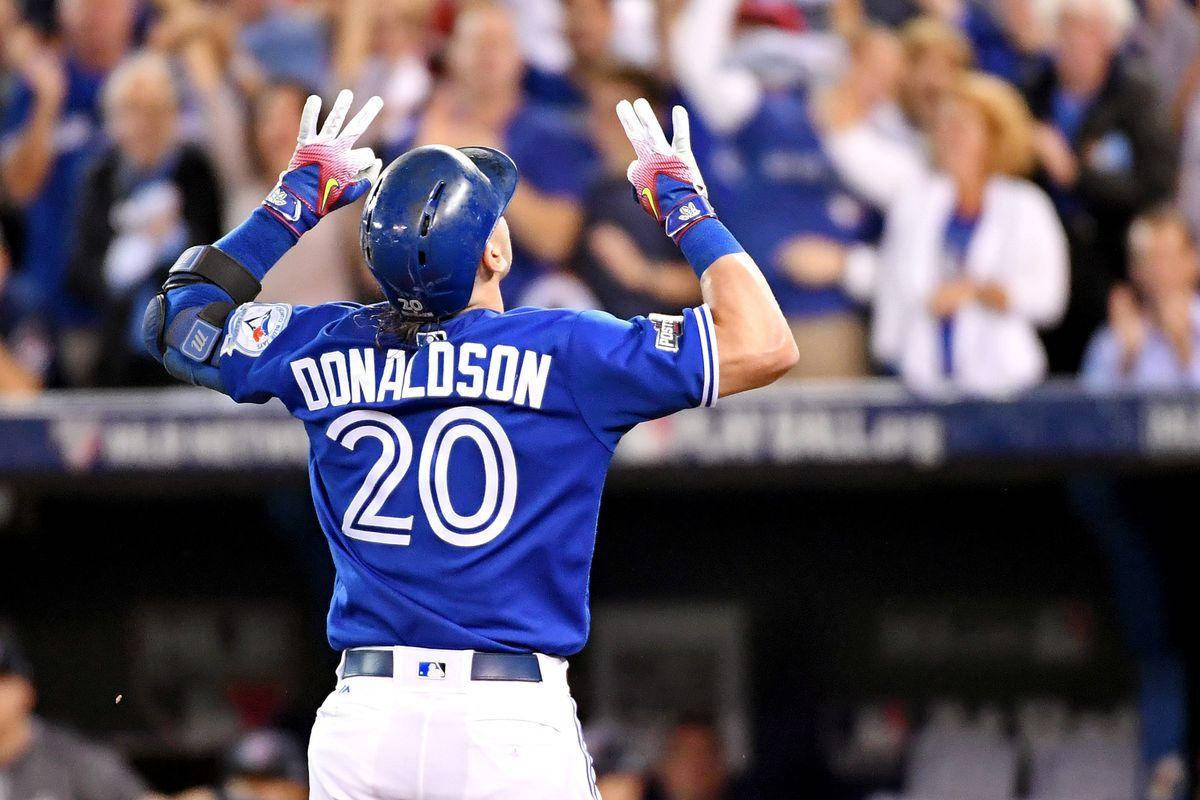 MLB 桌布 壁紙 — 身穿藍色球衣的棒球運動員唐納森20號在夜晚高舉戴著手套的雙手，向歡呼的球迷慶祝。