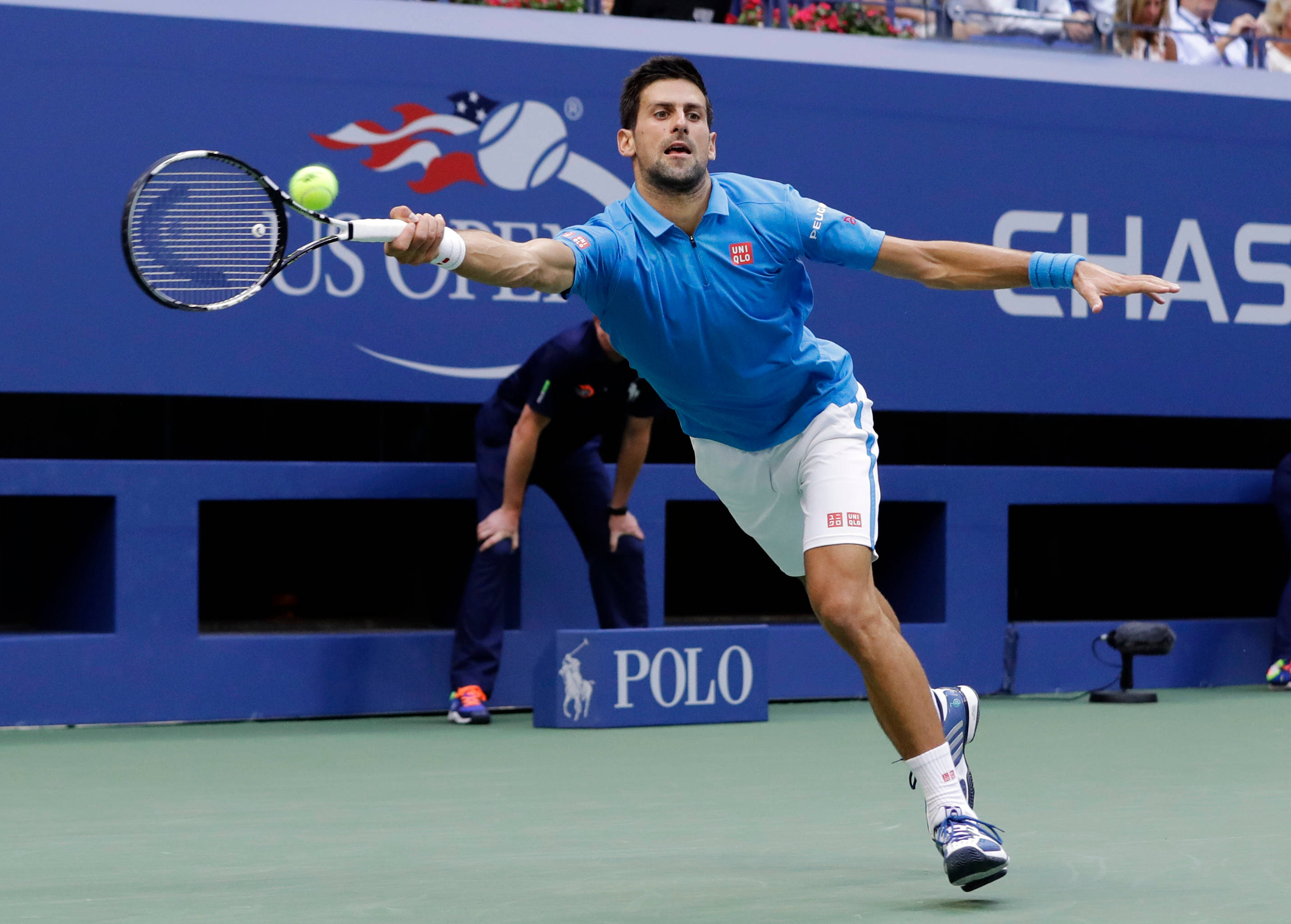 Novak 桌布 壁紙 — 身穿藍色襯衫的網球選手向前衝刺，在綠色球場上用球拍擊打綠色球。