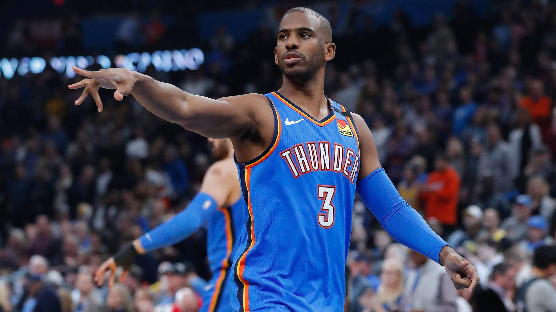 Chris Paul 桌布 壁紙 — 身穿藍色雷霆隊3號球衣的籃球運動員在比賽中激動地做手勢，背景有觀眾。