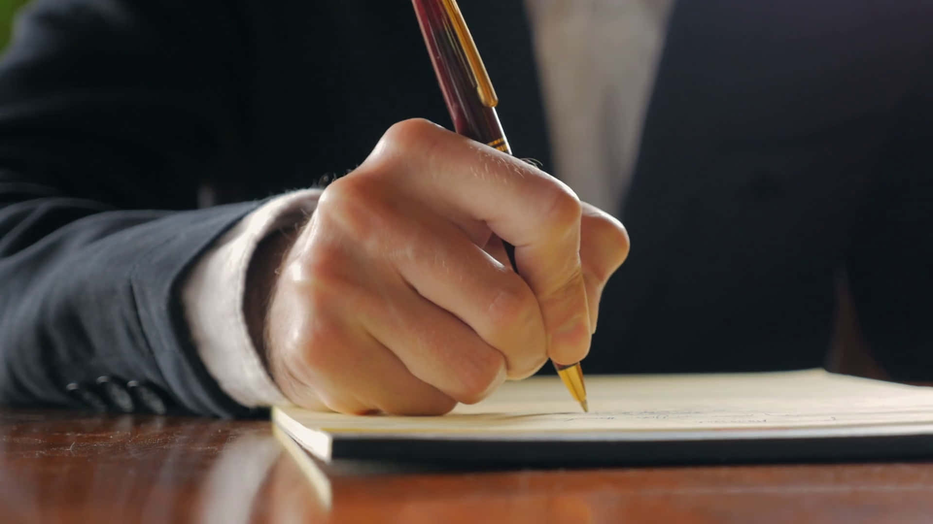 Handwriting 桌布 壁紙 — 身穿西裝的手在木桌上用金筆簽署文件的特寫。