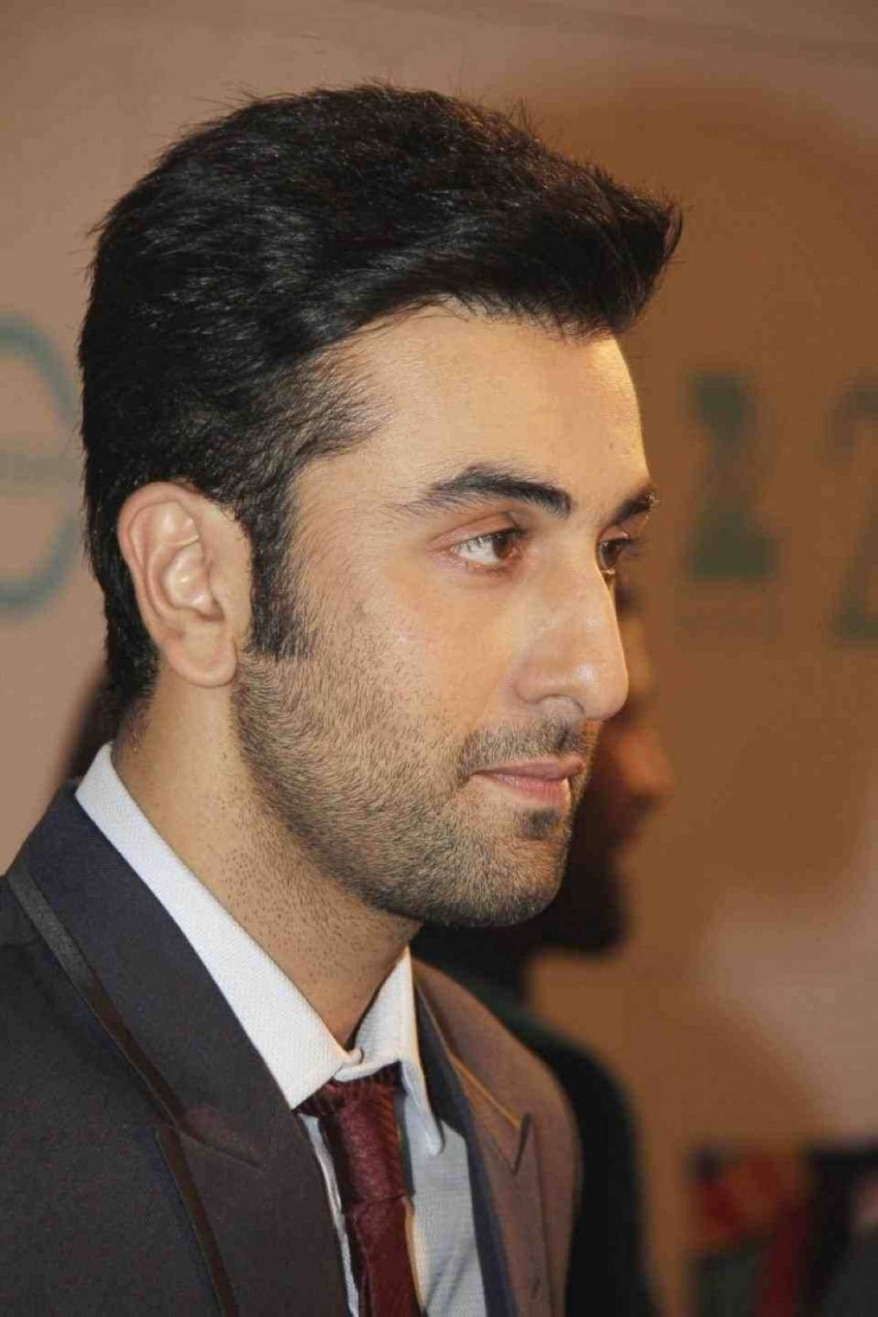 Ranbir Kapoor 桌布 壁紙 — 身穿西裝的男子近距離肖像照，表情嚴肅地望向一旁。