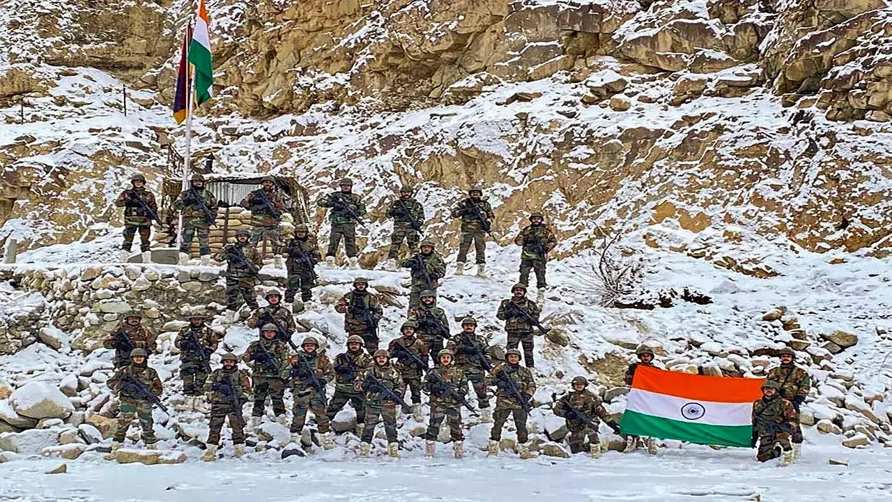 印度軍隊 桌布 壁紙 — 身穿迷彩服的印度士兵在白雪覆蓋的岩石山坡上列隊，手持國旗。