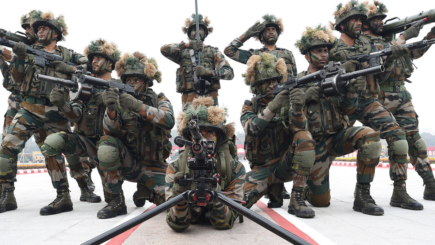 一群身穿迷彩裝備的武裝士兵在戶外列隊。 — 印度軍隊 壁紙
