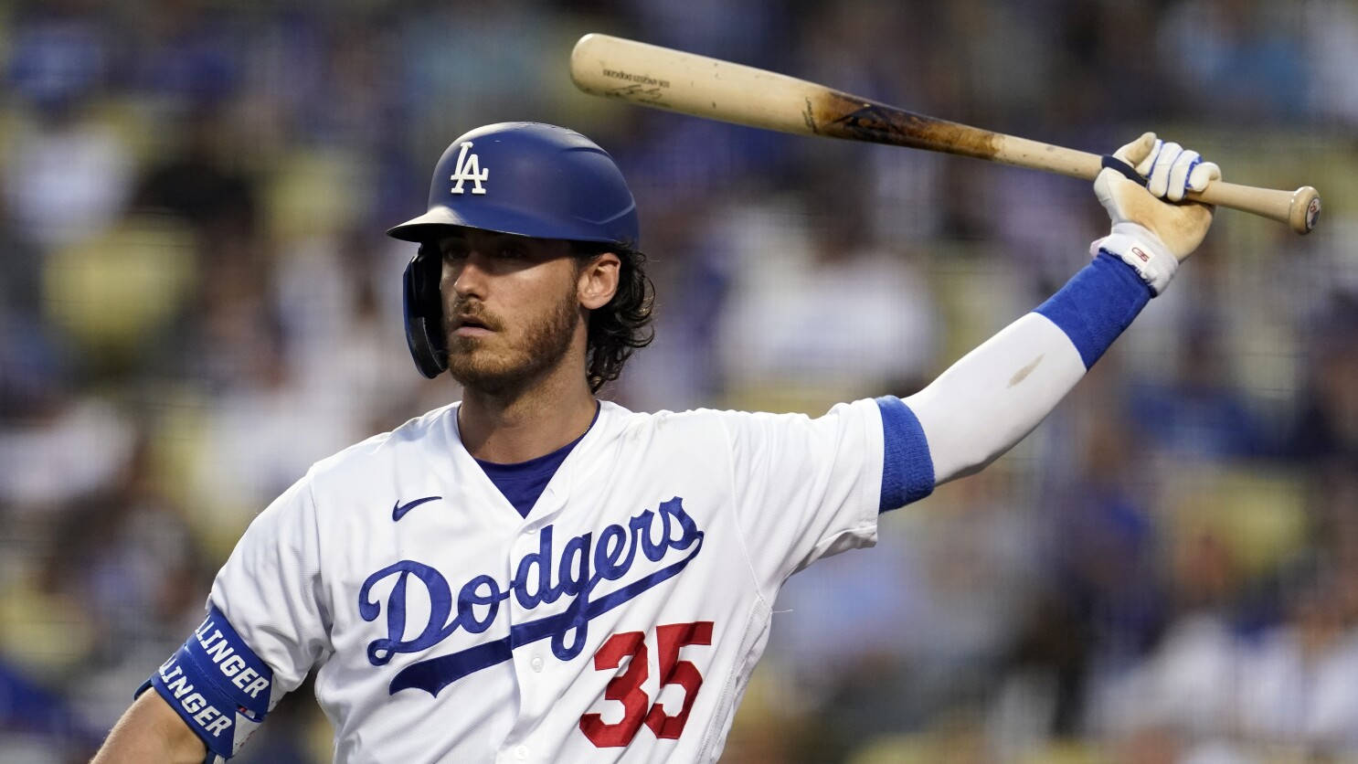 Cody 桌布 壁紙 — 身穿道奇隊球衣的棒球選手在球場上，在明亮燈光下高舉球棒，背景是模糊的人群。