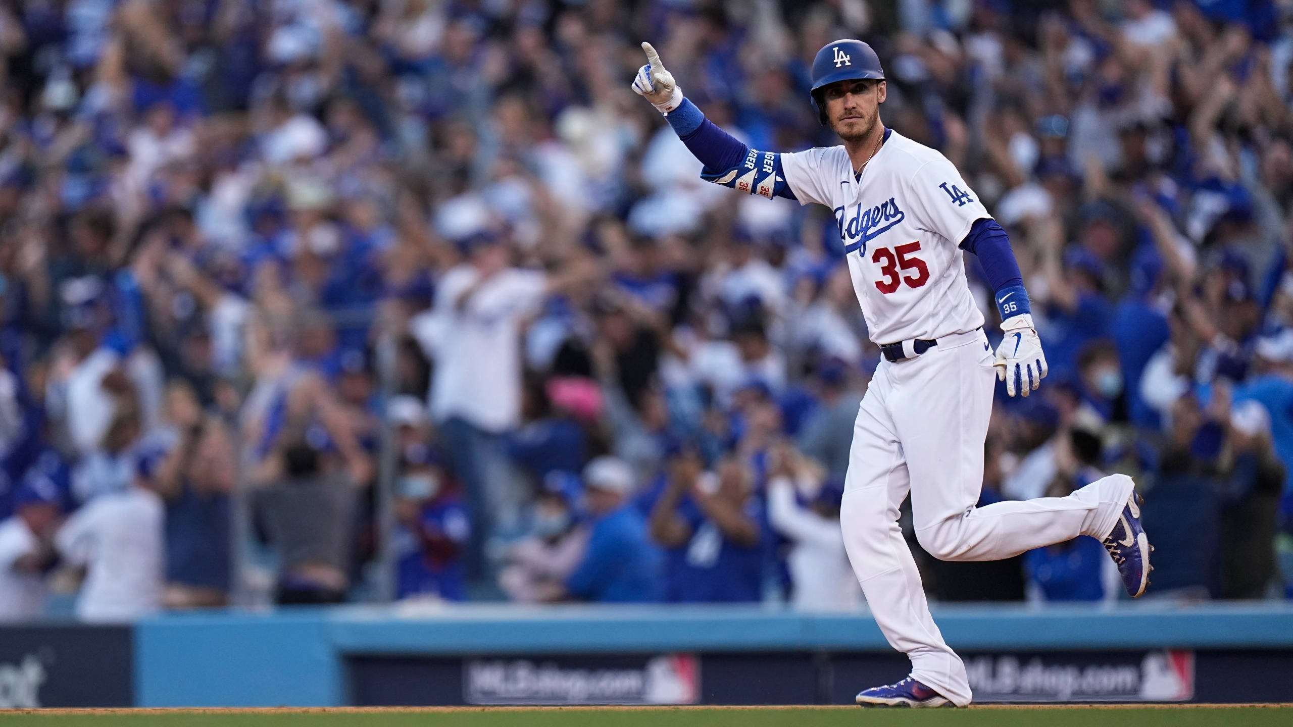 Cody 桌布 壁紙 — 身穿道奇隊球衣的棒球選手高舉拳頭慶祝，身後歡呼的群眾擠滿了球場。