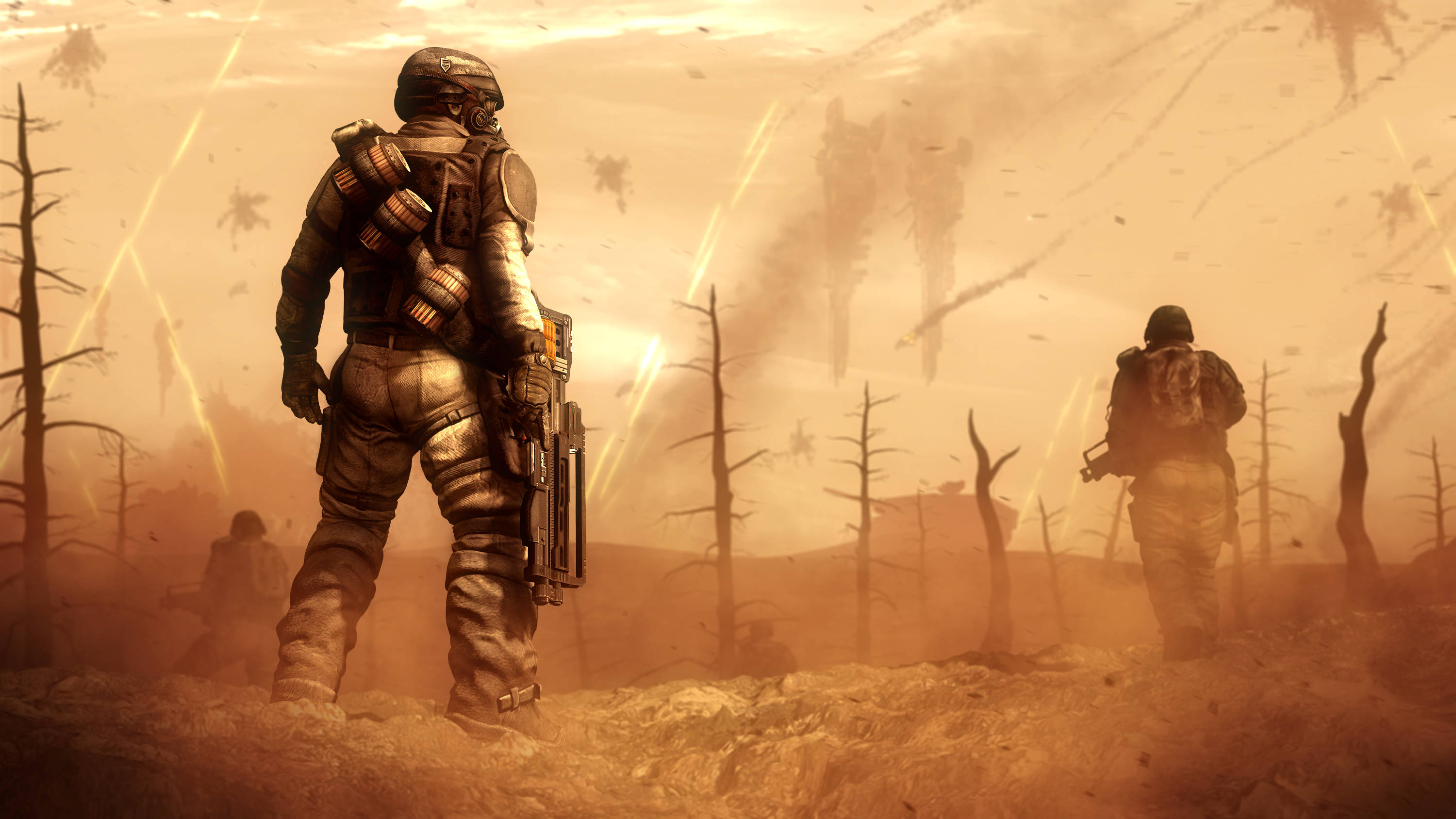 Wasteland 桌布 壁紙 — 身穿重型盔甲的士兵站在荒涼、燒焦的廢土上，天空朦朧橙色，有枯樹和遠處的爆炸。