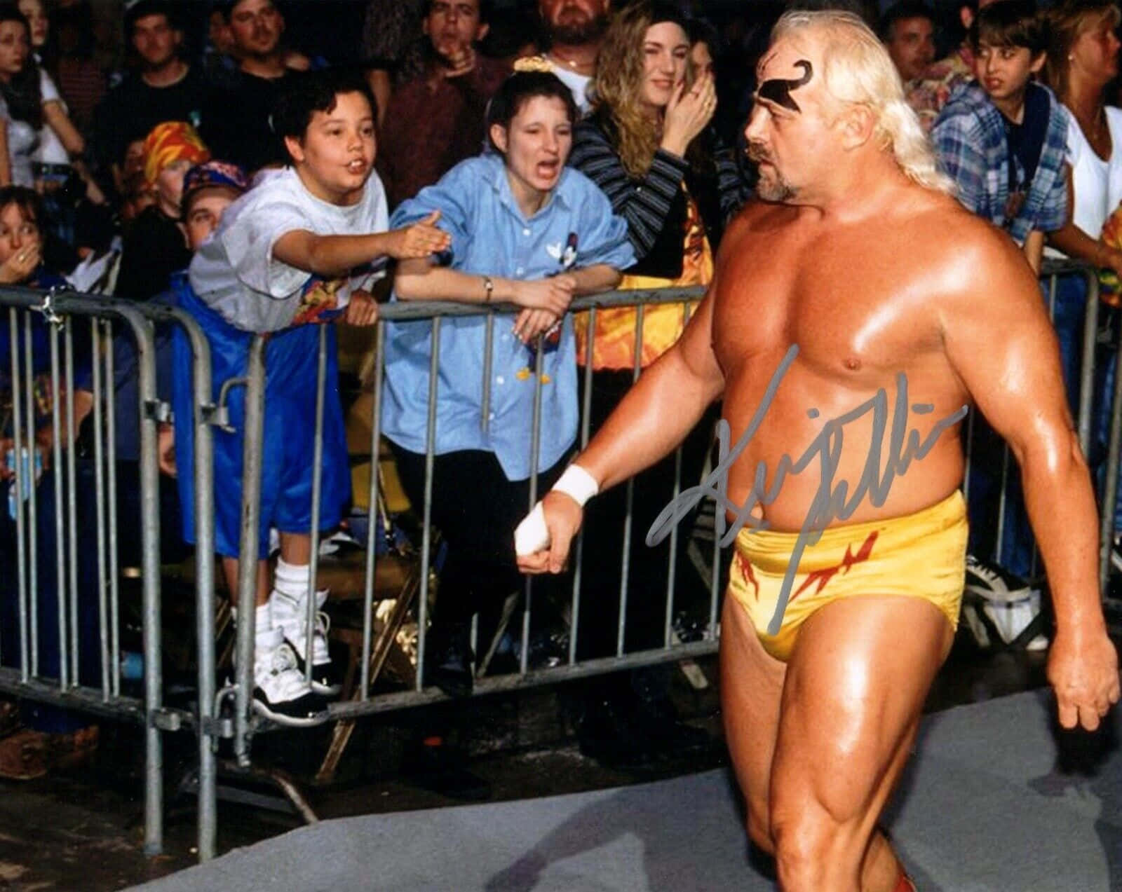 WWE 桌布 壁紙 — 身穿黃色短褲的Hulk Hogan自信地走過金屬圍欄後歡呼的粉絲，這是一場摔角活動。