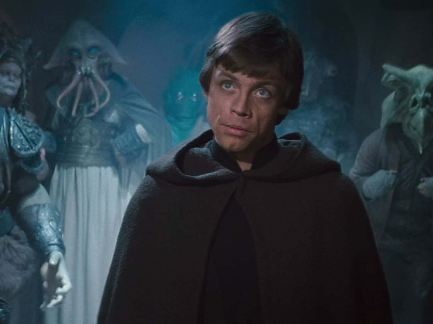 Return Of The Jedi 桌布 壁紙 — 身穿黑色斗篷的Luke Skywalker莊嚴地站立，而外星生物在迷霧籠罩的藍色房間中隱約出現。
