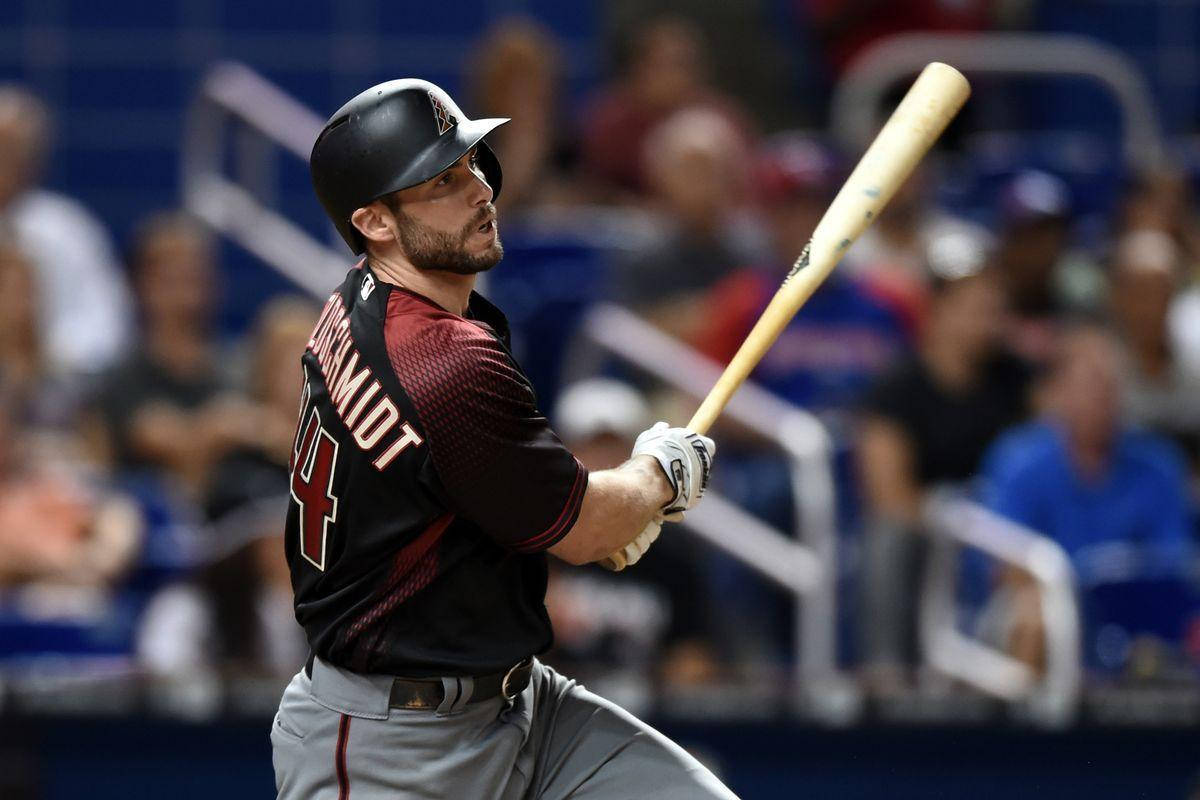 Paul Goldschmidt 桌布 壁紙 — 身穿黑色球衣的棒球運動員，在模糊的體育場觀眾背景下，專注地揮動木製球棒。