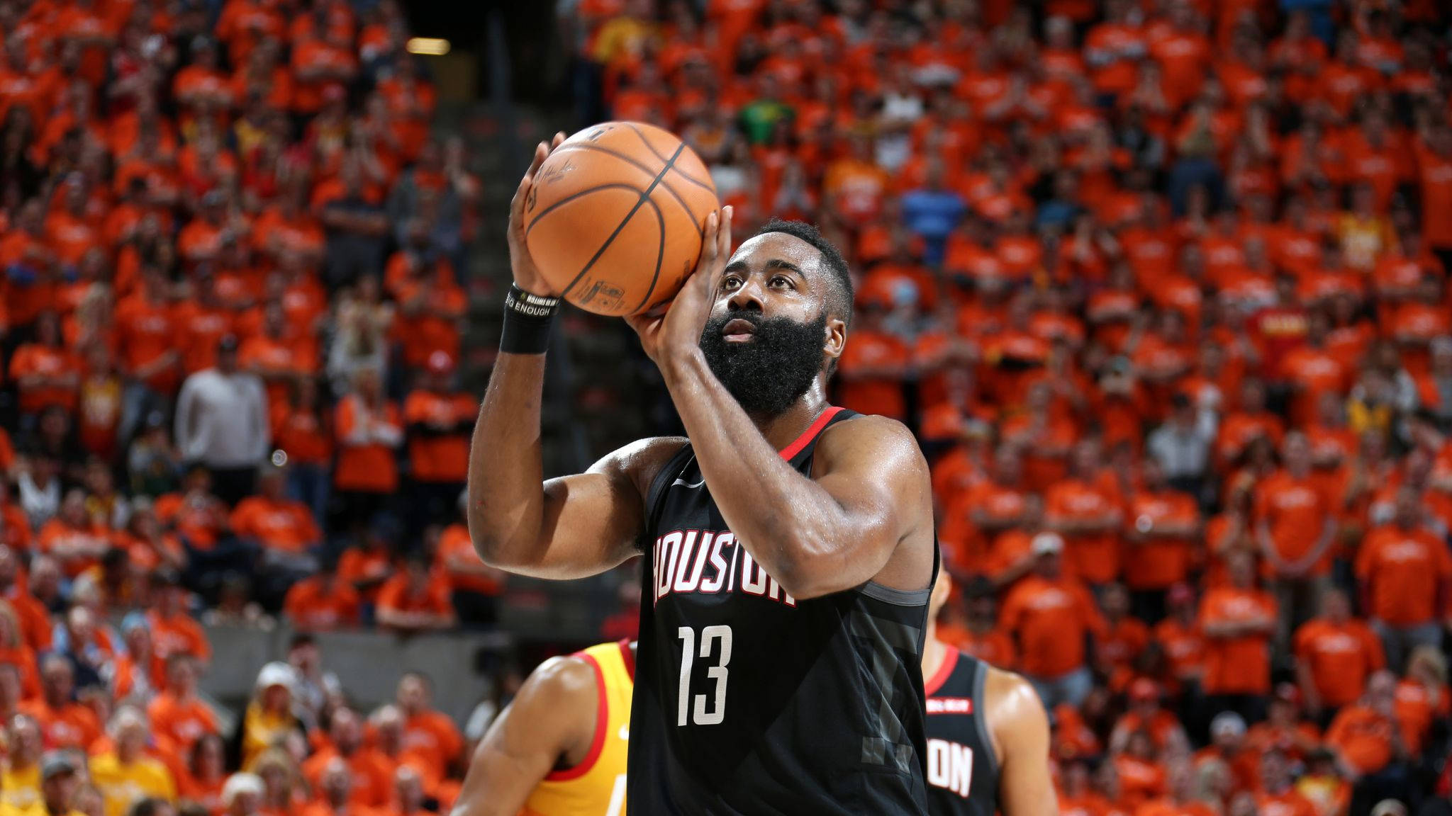 James Harden 桌布 壁紙 — 身穿黑色球衣的籃球運動員在擠滿橙色衣著球迷的場館中準備投籃。