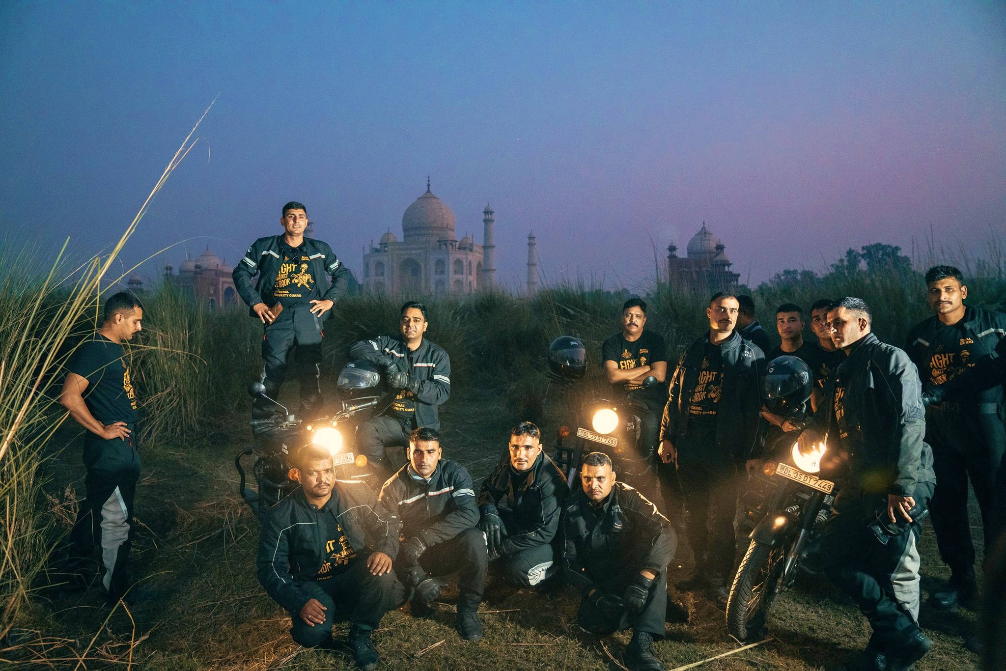 Indian 桌布 壁紙 — 身穿黑色裝備的機車騎士在黃昏時與機車合影，背景中泰姬陵微微發光。