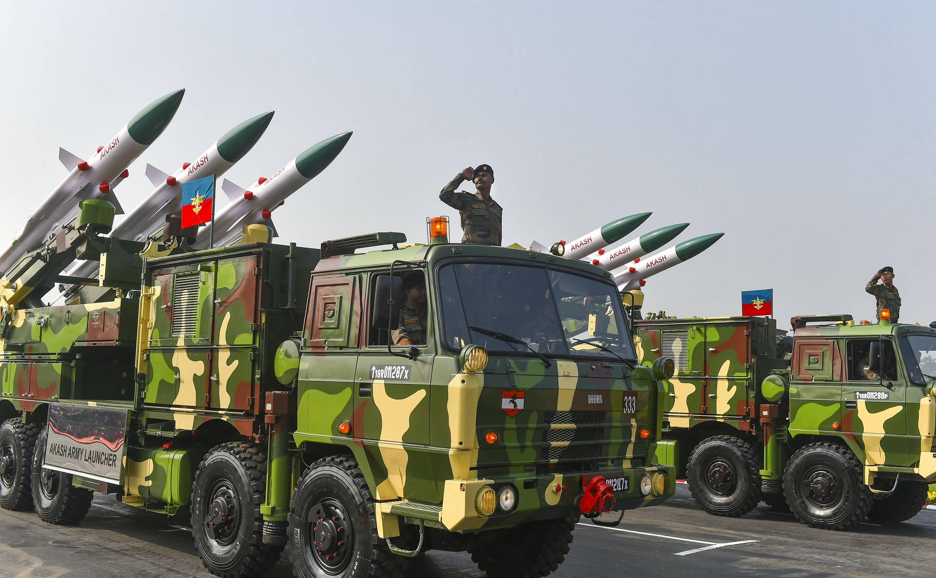閱兵期間軍用卡車運載阿卡什導彈，士兵敬禮。