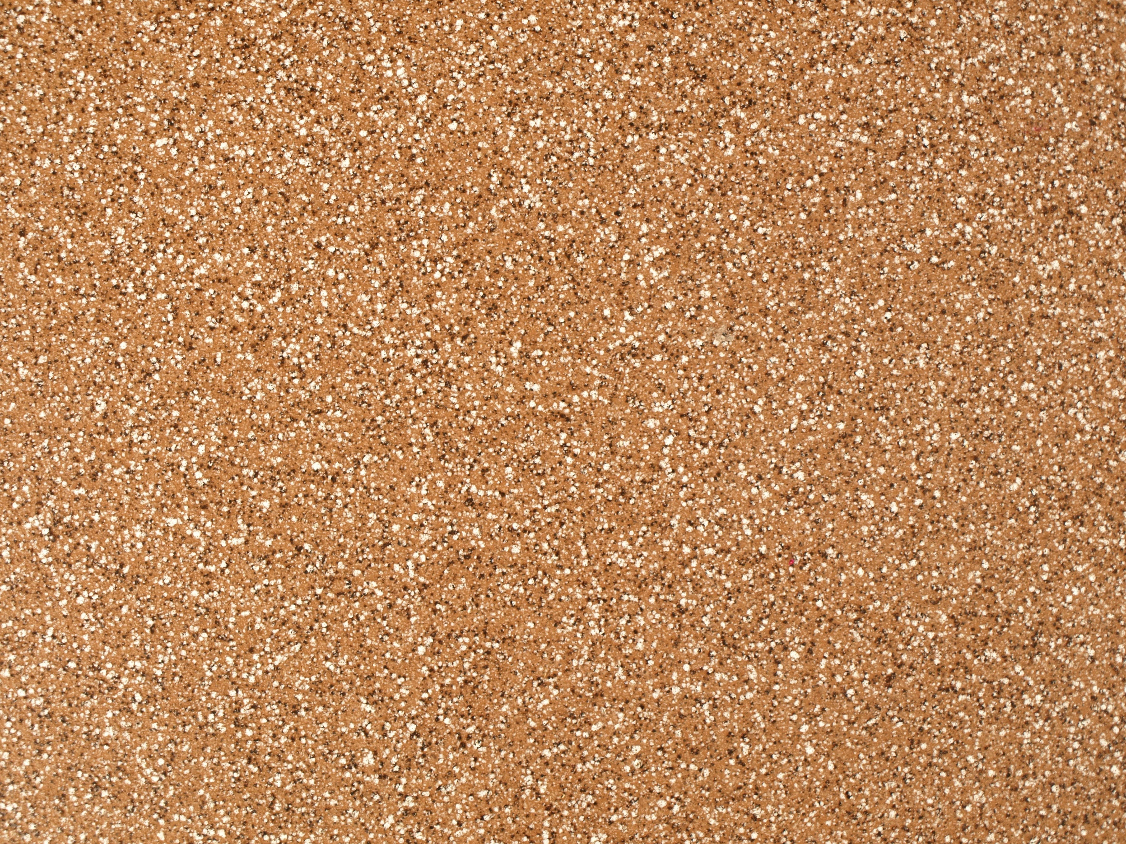 texture 桌布 壁紙 — 軟木表面特寫，帶有紋理、散落的白色斑點和溫暖的棕色色調。