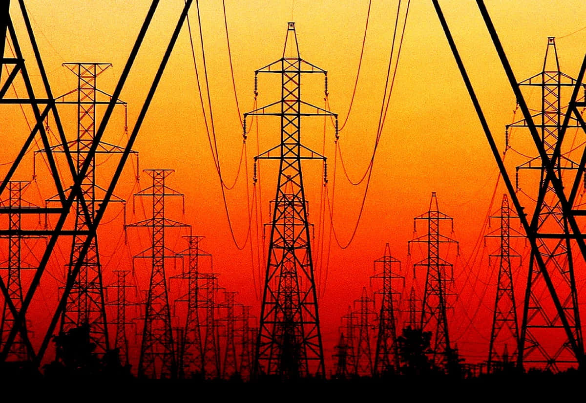 電力 桌布 壁紙 — 輸電塔的剪影在火紅的橙紅色日落天空中延伸。