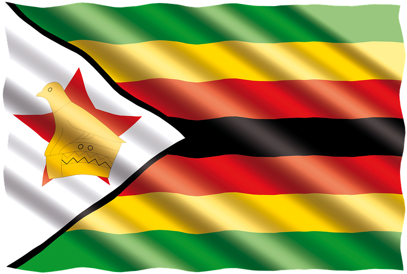 Zimbabwe 桌布 壁紙 — 辛巴威國旗動態飄揚，帶有綠色、黃色、紅色和黑色條紋，以及一個白色三角形，內有紅星上的金色鳥。
