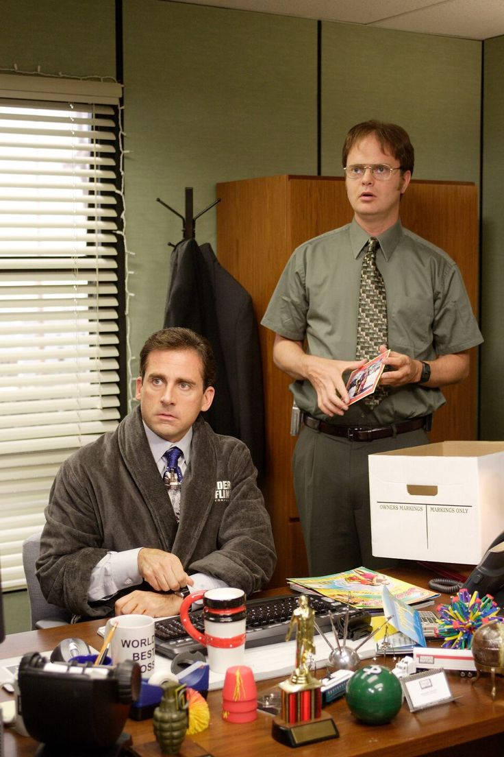 Michael Scott 桌布 壁紙 — 辦公室裡有兩個男人，一個穿著長袍坐在雜亂的辦公桌前，另一個站著拿著一張卡片。