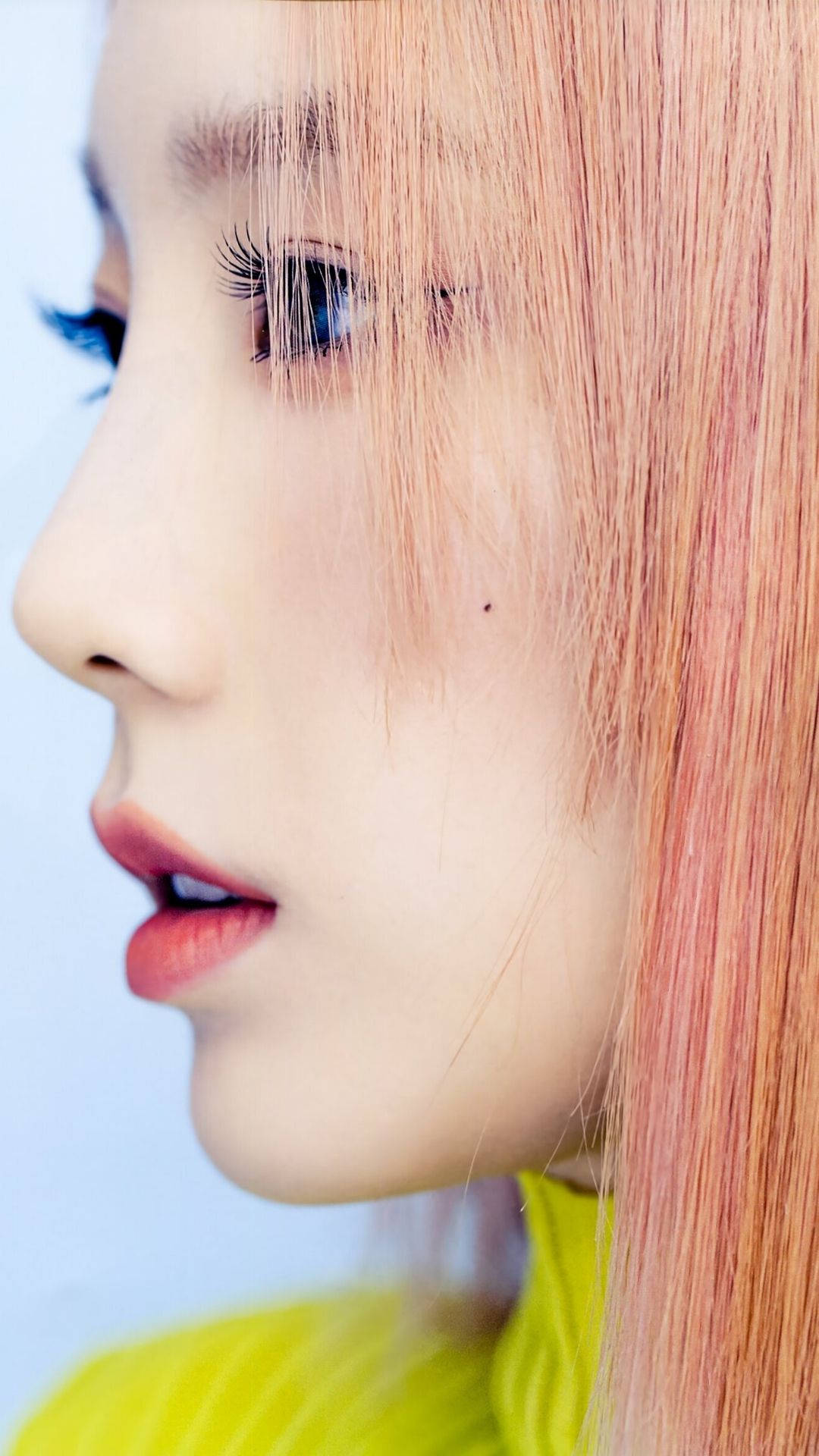 Taeyeon 桌布 壁紙 — 近距離人像，人物擁有蜜桃色頭髮和亮黃色上衣，背景為柔和藍色。
