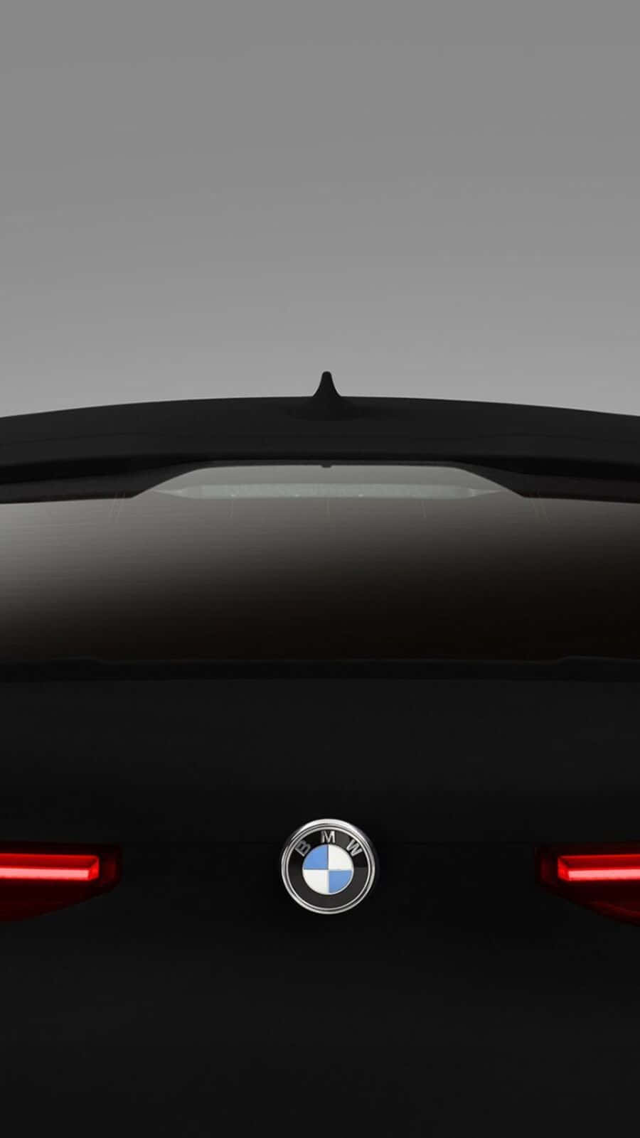 Vantablack 桌布 壁紙 — 近距離後視圖，一輛時尚的黑色BMW汽車，帶有發光的紅色尾燈，背景為簡約灰色。