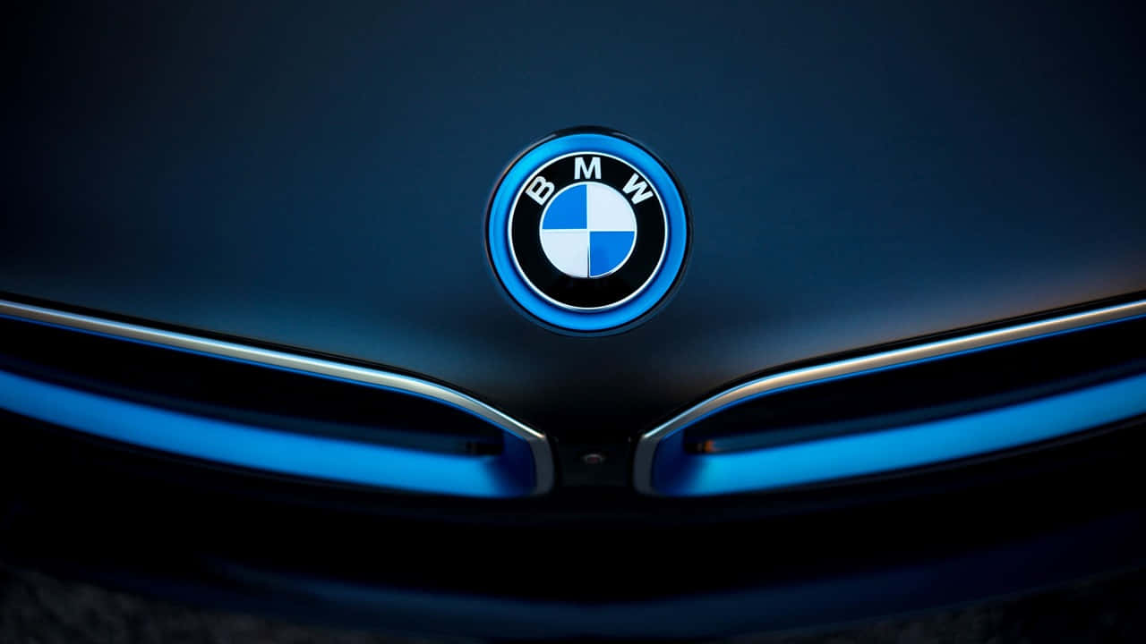 720p Bmw 桌布 壁紙 — 近距離拍攝BMW標誌在時尚引擎蓋上發出藍光，燈光效果戲劇化。