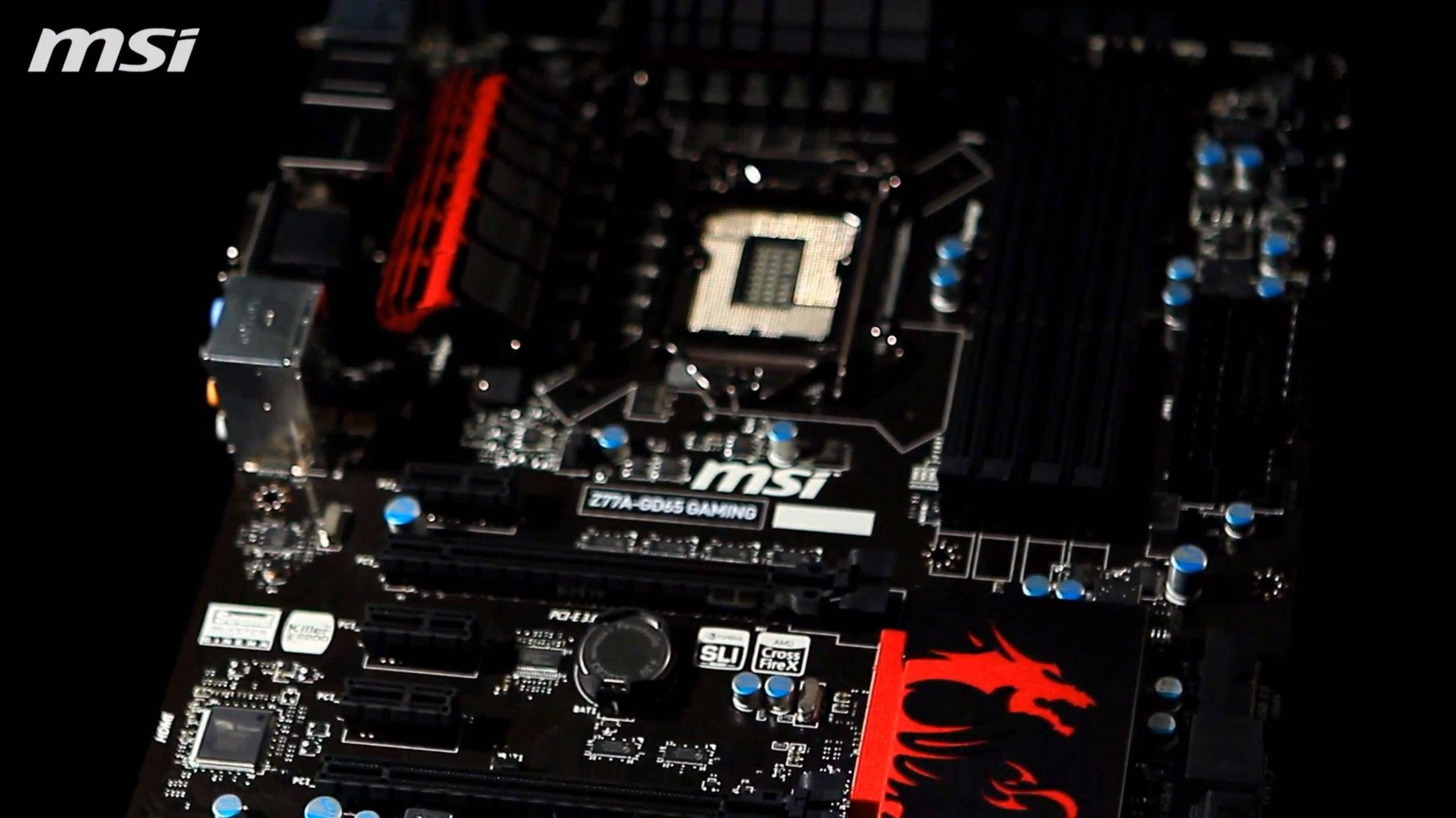 Motherboard 桌布 壁紙 — 近距離拍攝MSI遊戲主機板，帶有紅色龍標誌和藍色電容器，背景為黑色。