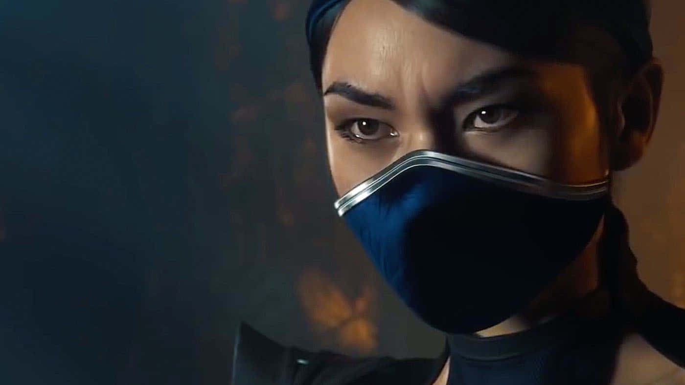 Mortal Kombat Kitana 桌布 壁紙 — 近距離拍攝一位戴著深藍色面具、眼神銳利的蒙面戰士，處於溫暖戲劇性燈光下。