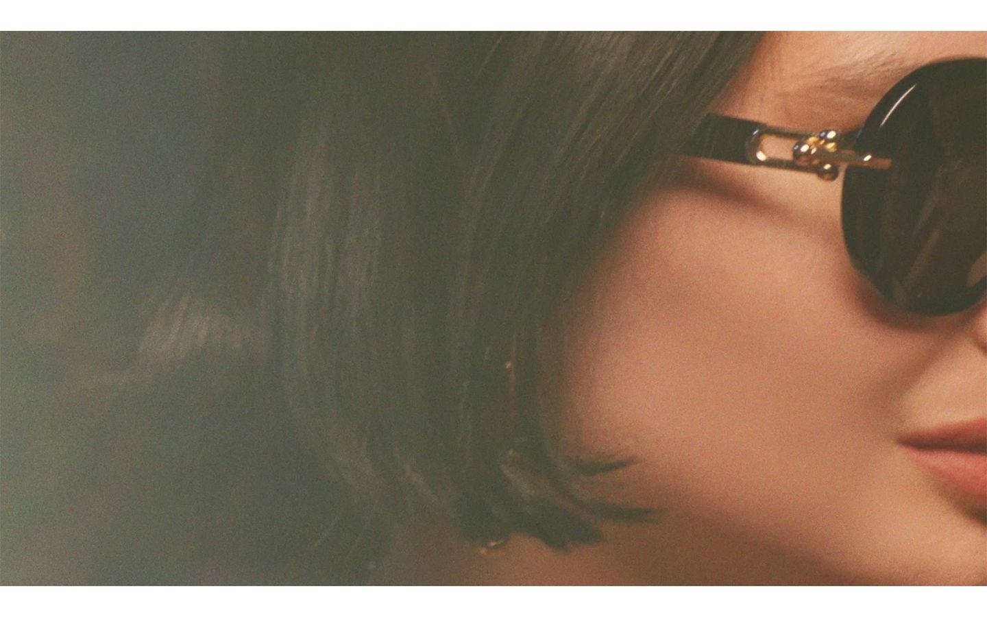 Sunglasses 桌布 壁紙 — 近距離拍攝一位短黑髮人士，戴著時尚的圓形太陽眼鏡，帶有金色點綴。