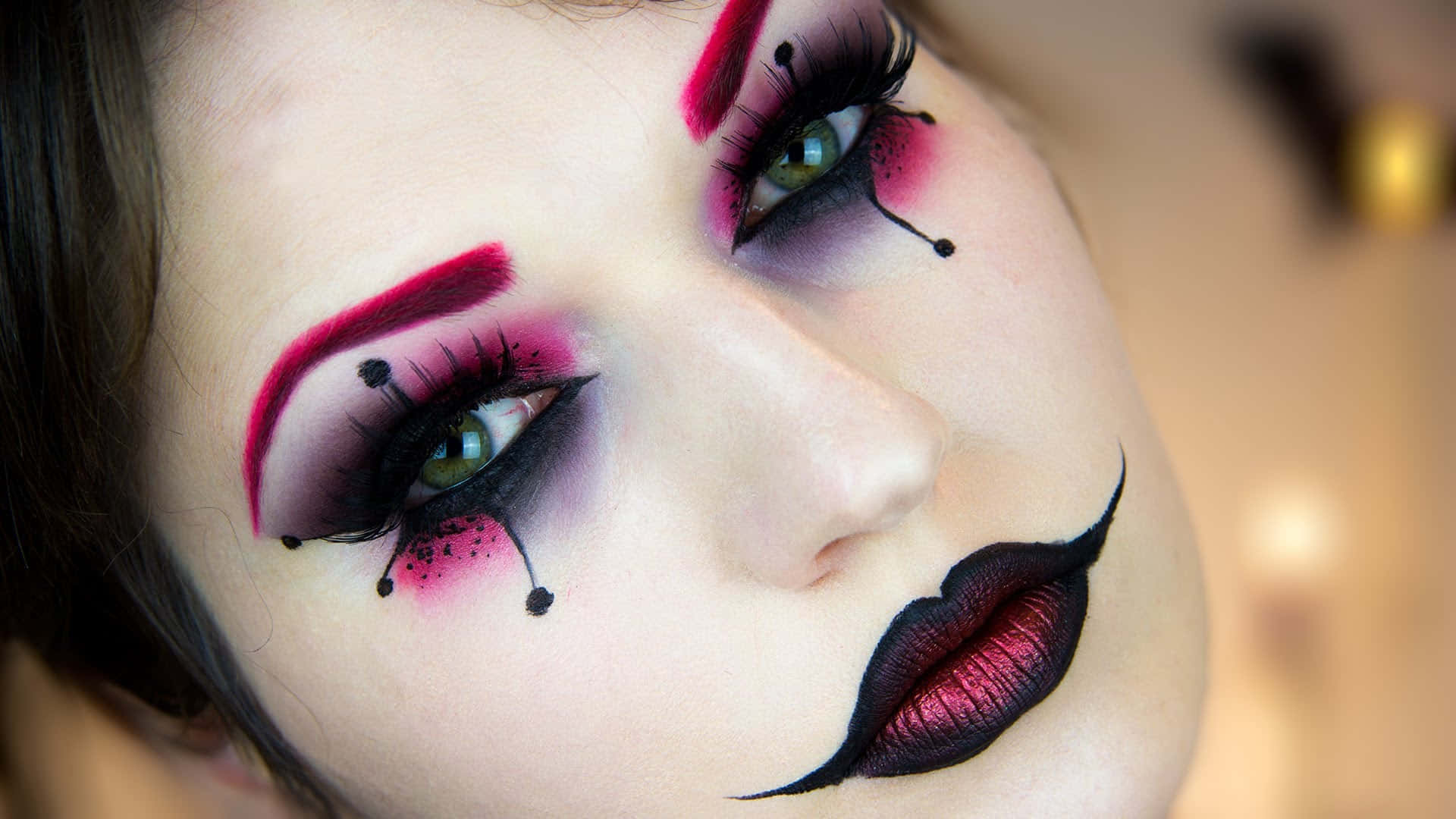 Halloween Makeup 桌布 壁紙 — 近距離拍攝一個人，臉上帶有戲劇化的小丑妝容，特點是大膽的粉紅色和黑色點綴以及淚滴細節。
