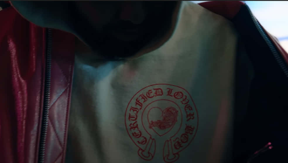 標誌 桌布 壁紙 — 近距離拍攝一個人穿著紅色皮夾克，內搭白色T恤，上面有紅色的「Certified Lover Boy」標誌。