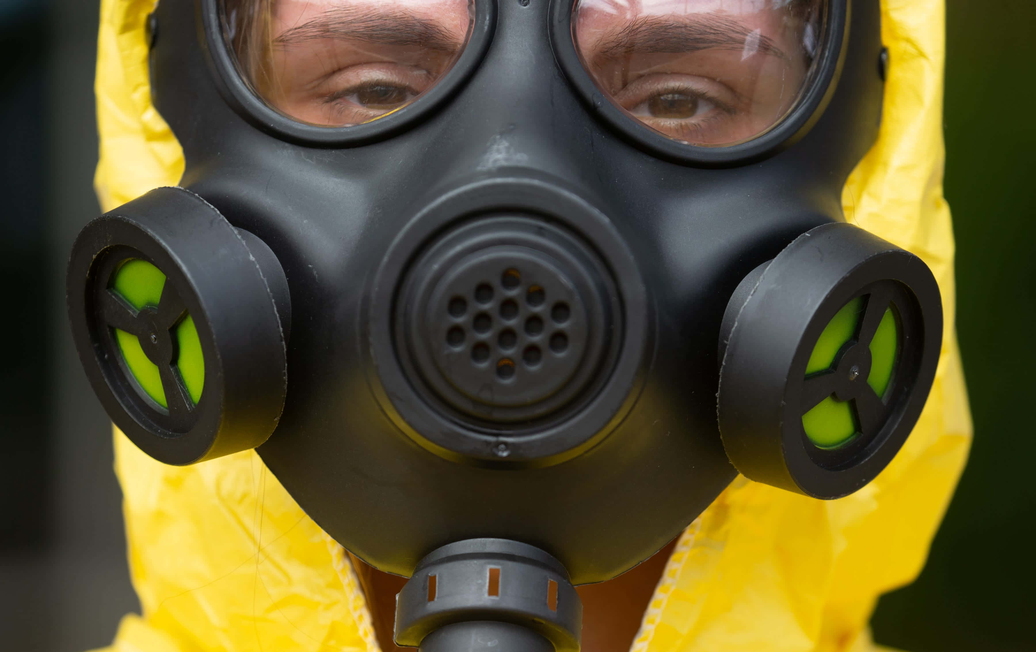 Mask 桌布 壁紙 — 近距離拍攝一個人穿著黃色防護服，戴著黑色防毒面具和發光綠色濾鏡。