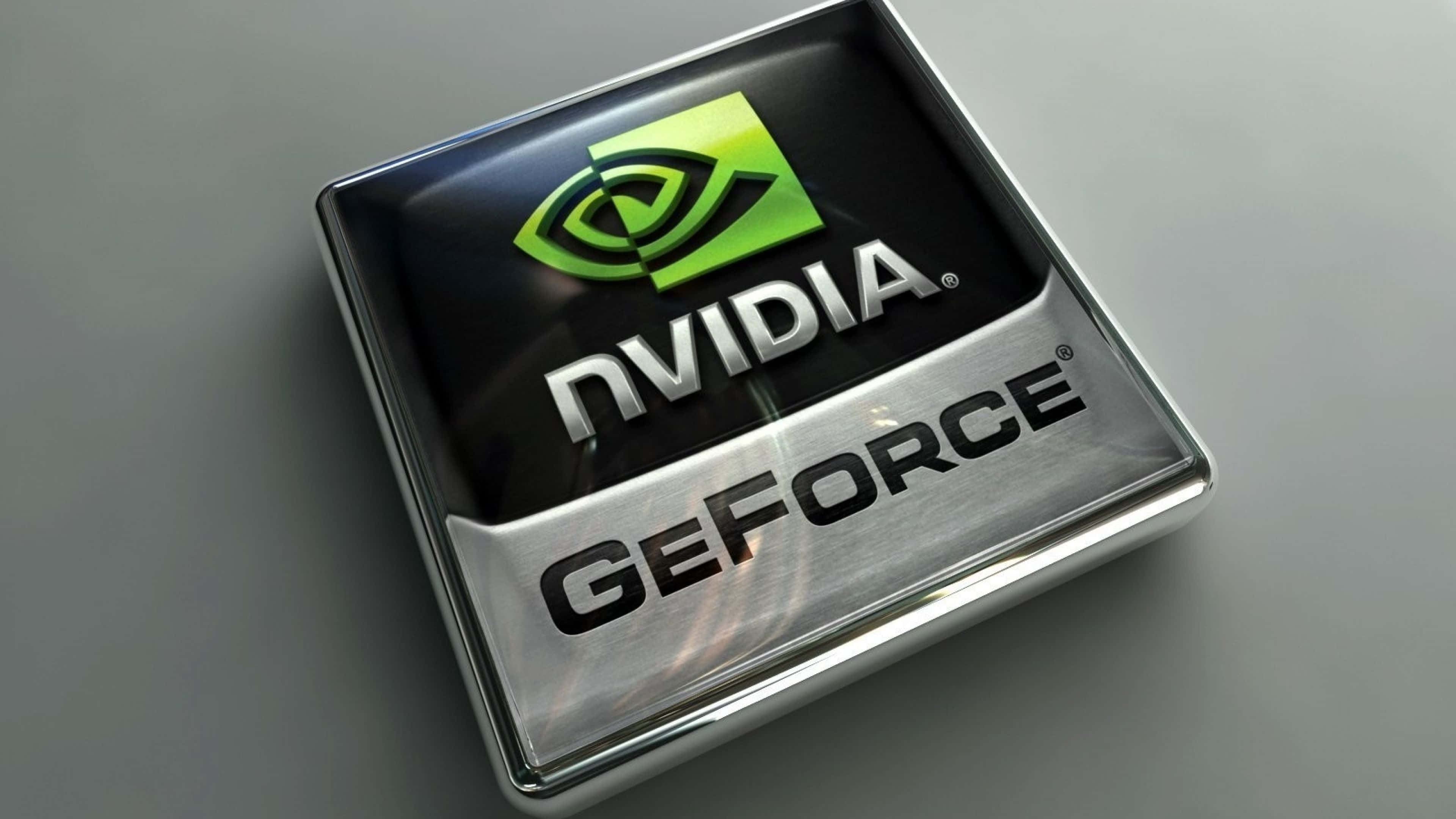 Forces 桌布 壁紙 — 近距離拍攝一個光滑的NVIDIA GeForce標誌，位於金屬方形徽章上，帶有綠色眼睛標誌和銀色文字。