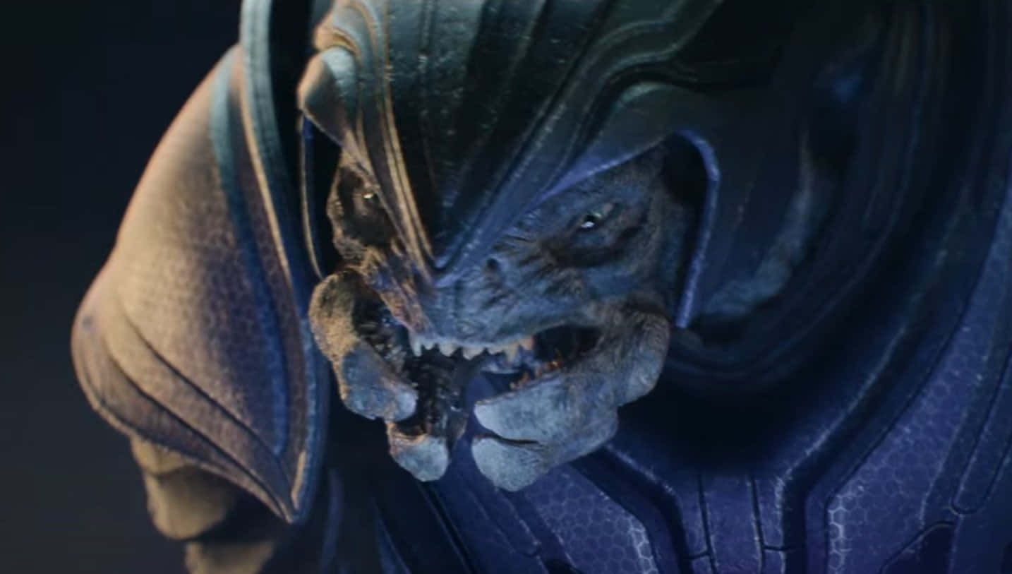 Halo Covenant 桌布 壁紙 — 近距離拍攝一個帶有鋒利牙齒和裝甲藍色皮膚的威脅性外星生物，處於昏暗光線下。
