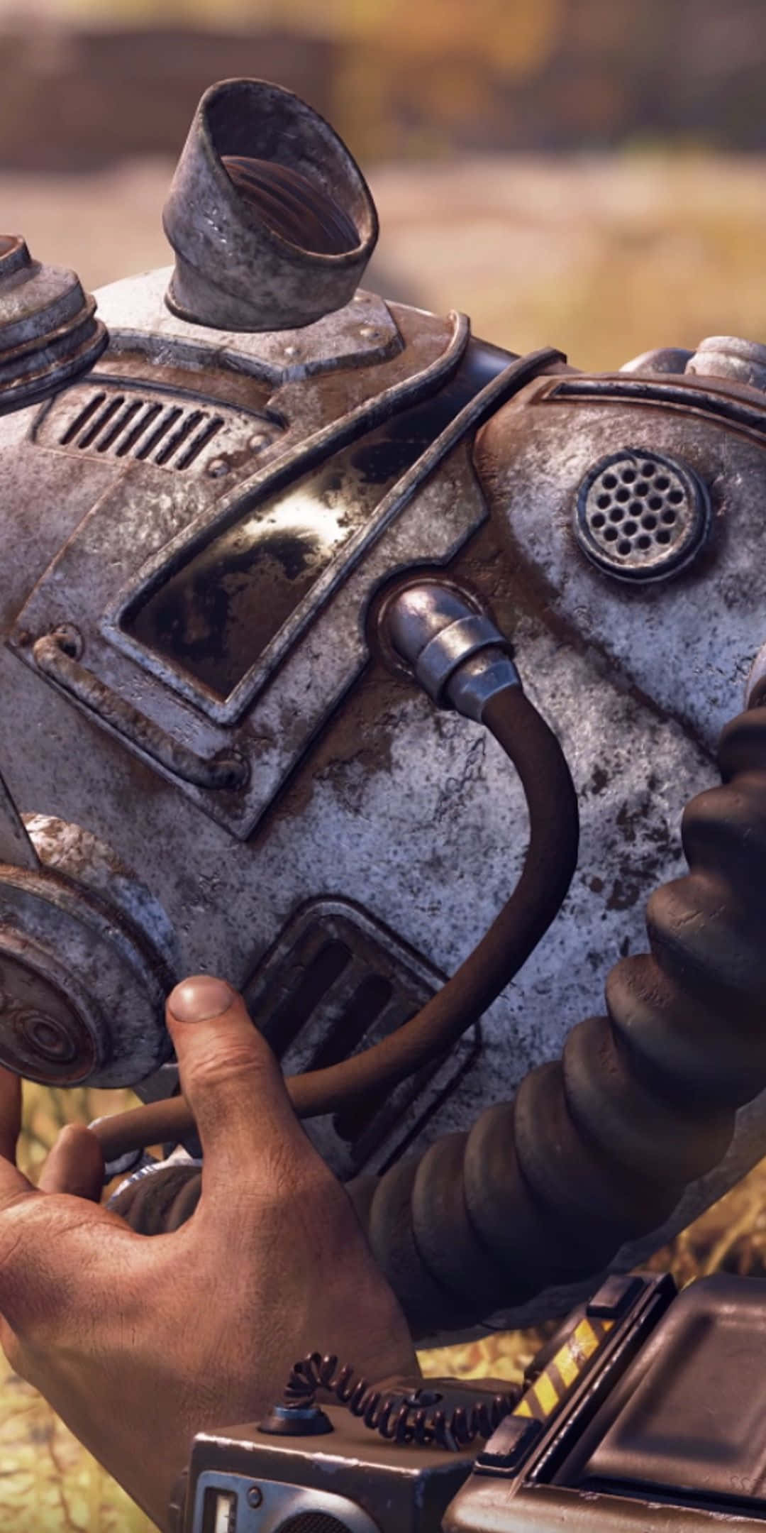 Pixel 3 Fallout 76 桌布 壁紙 — 近距離拍攝一個風化的動力裝甲頭盔，一隻手正在調整其磨損的通訊設備。