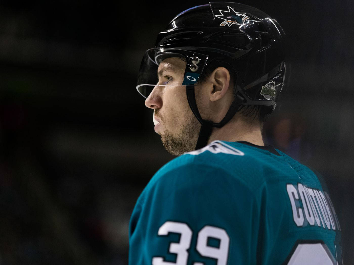 hockey 桌布 壁紙 — 近距離拍攝一名冰球運動員，身穿青綠色39號球衣，背部可見名字COTTON，比賽中戴黑色頭盔。