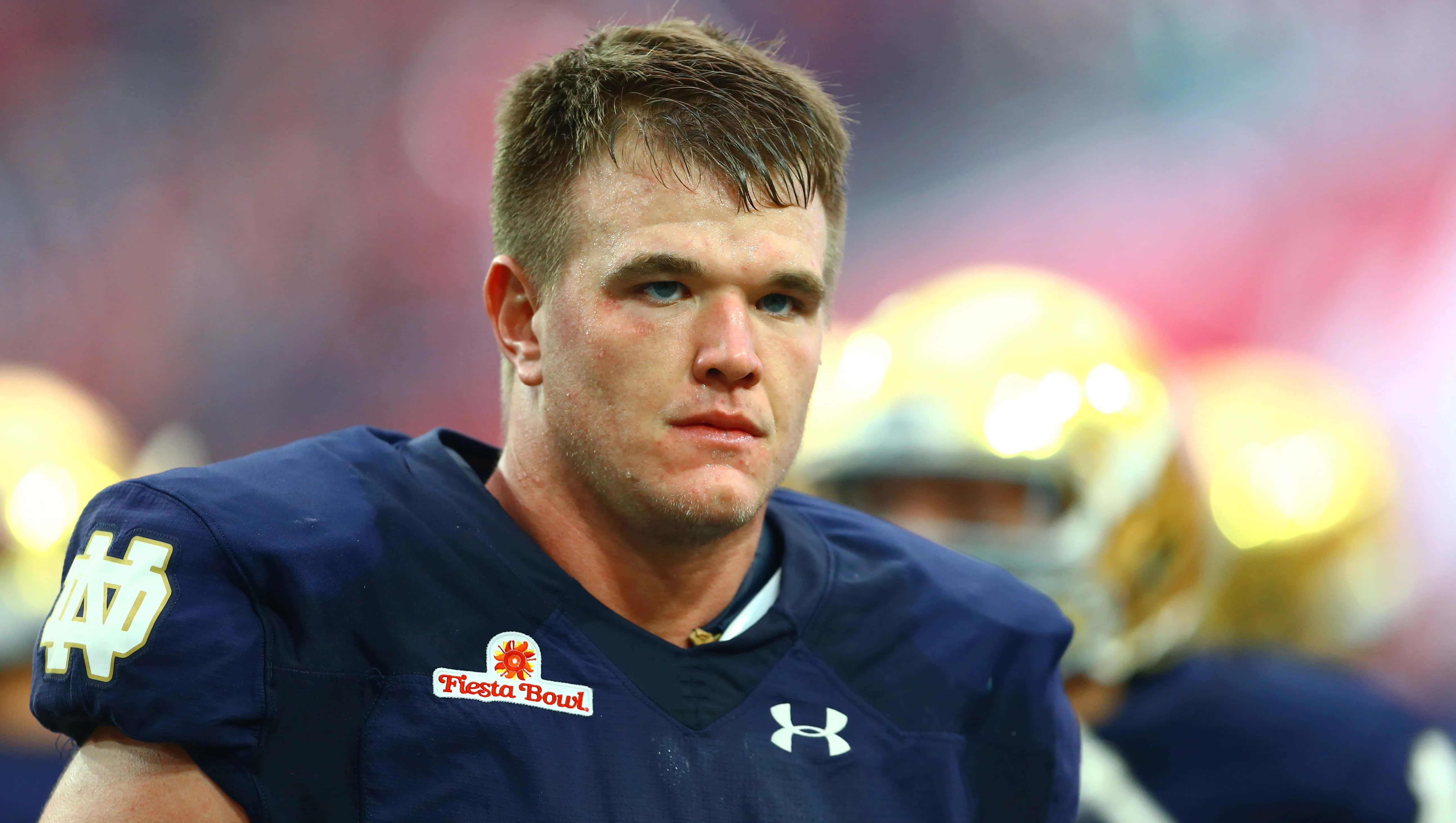 Mike Mcglinchey 桌布 壁紙 — 近距離拍攝一名專注的足球員，身穿深藍色聖母大學球衣，帶有Fiesta Bowl臂章，比賽中。