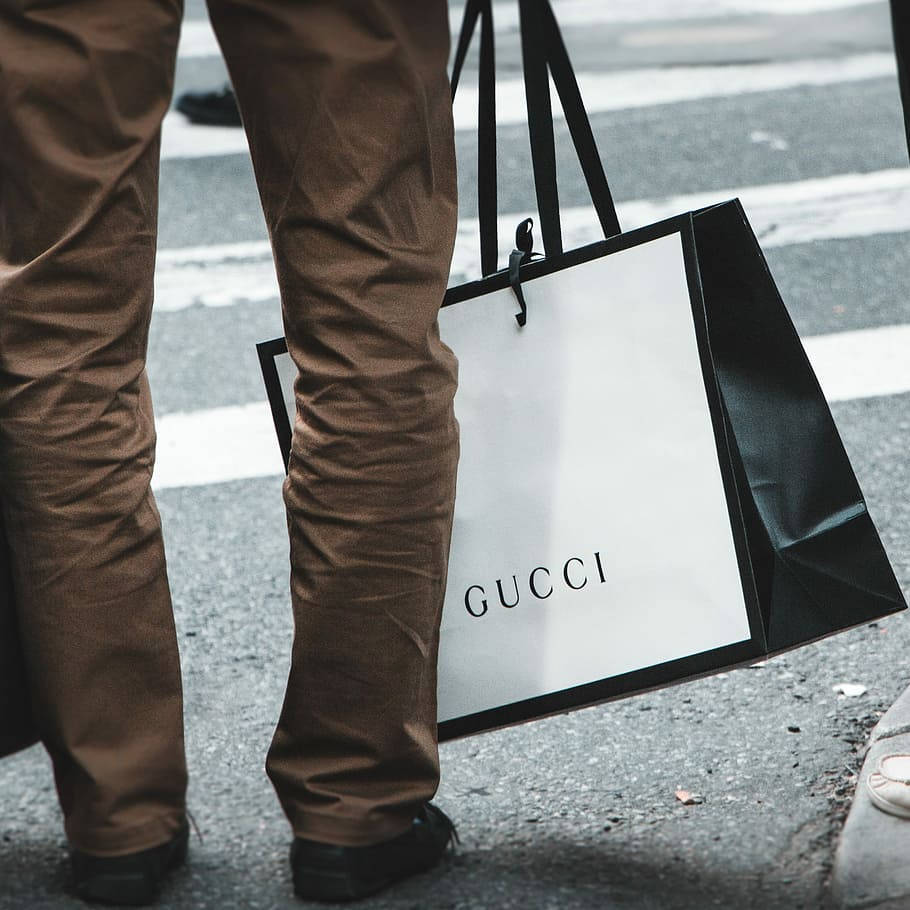 人在城市人行道上拿著Gucci購物袋行走 — Gucci GIF 壁紙