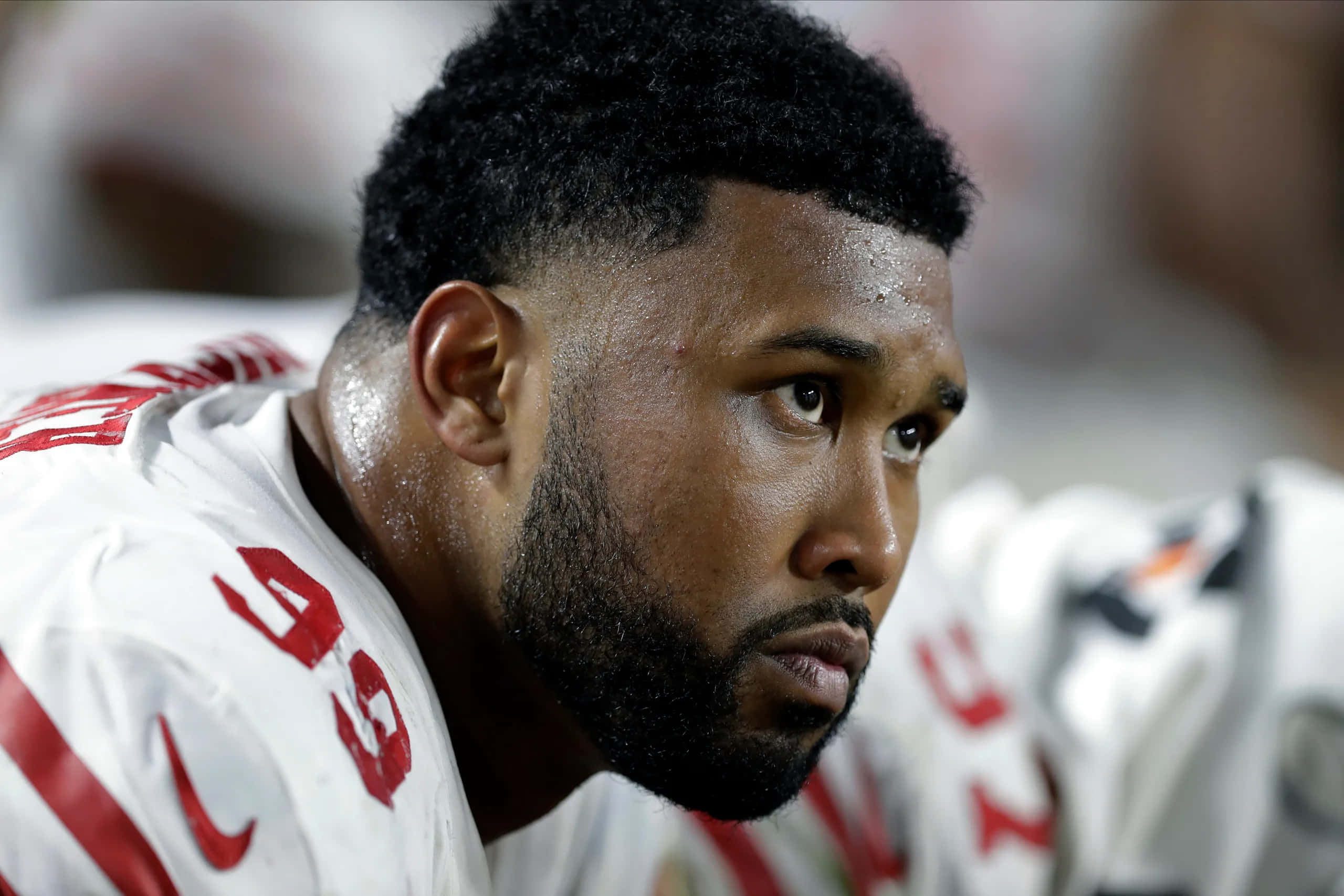Football Players 桌布 壁紙 — 近距離拍攝一名身穿白色和紅色球衣、汗流浹背的足球運動員在比賽中專注地望向鏡頭外。