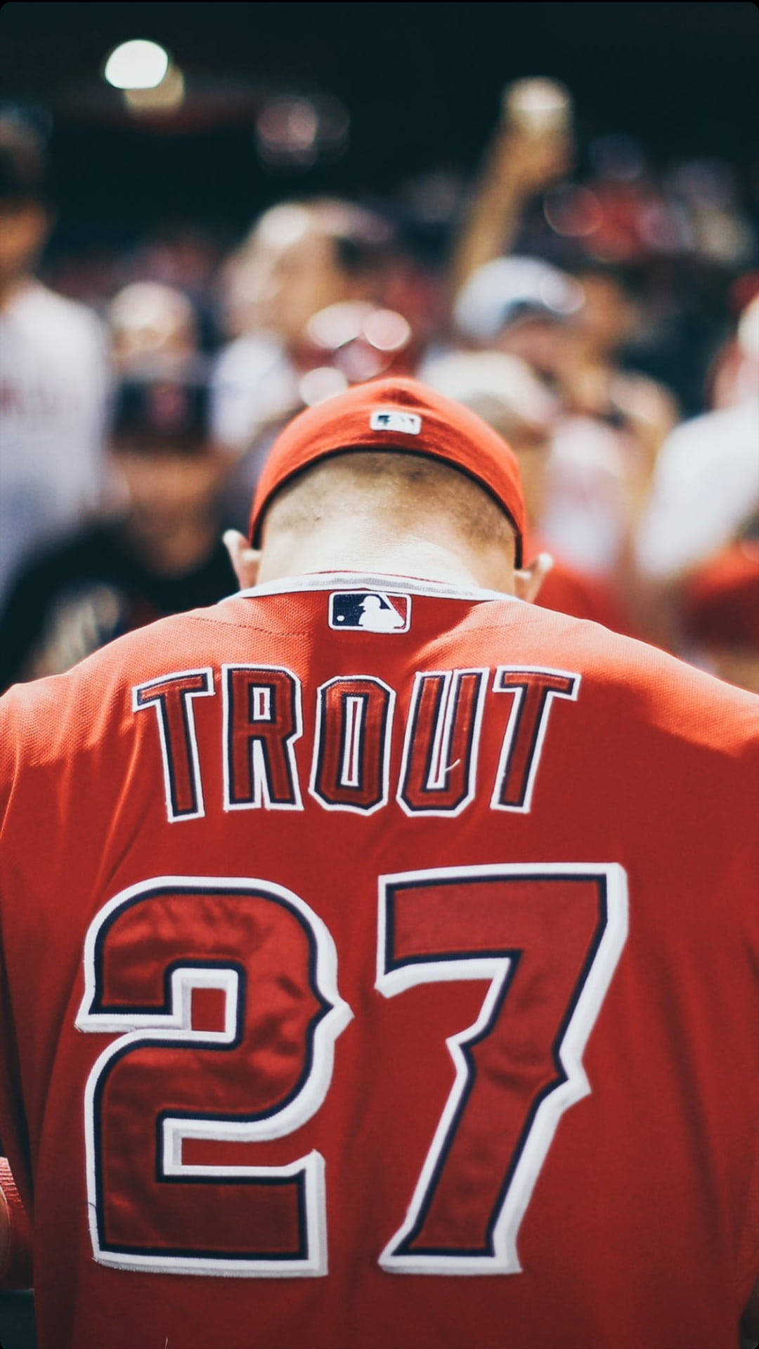 Mike Trout 桌布 壁紙 — 近距離拍攝一名身穿紅色Trout 27球衣的棒球運動員，背景是模糊的人群。
