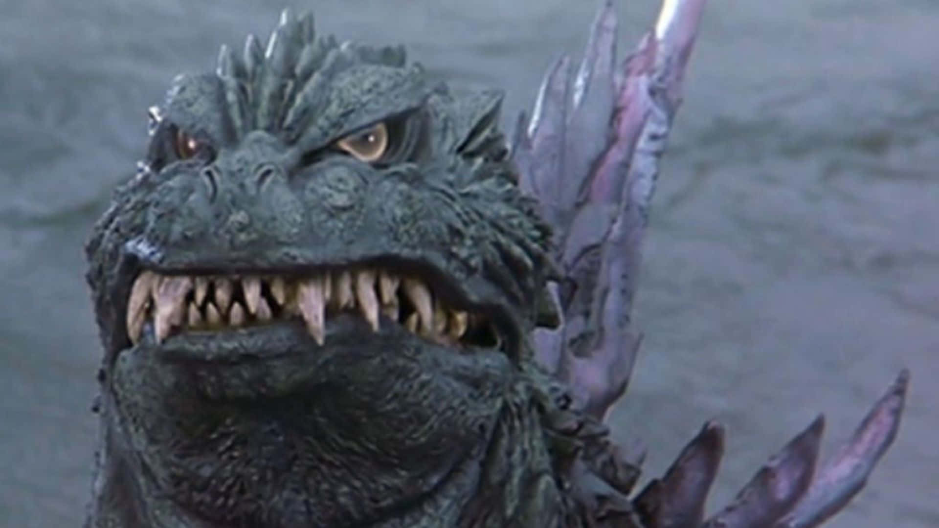 Godzilla 2000 桌布 壁紙 — 近距離拍攝一隻咆哮的哥吉拉，背上有尖刺，露出鋒利牙齒，從渾濁的水中冒出。