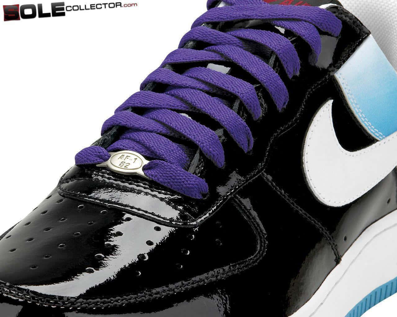 Black Air Force 桌布 壁紙 — 近距離拍攝一雙亮黑色Nike運動鞋，搭配大膽的紫色鞋帶和白色勾勾，背景為純白色。
