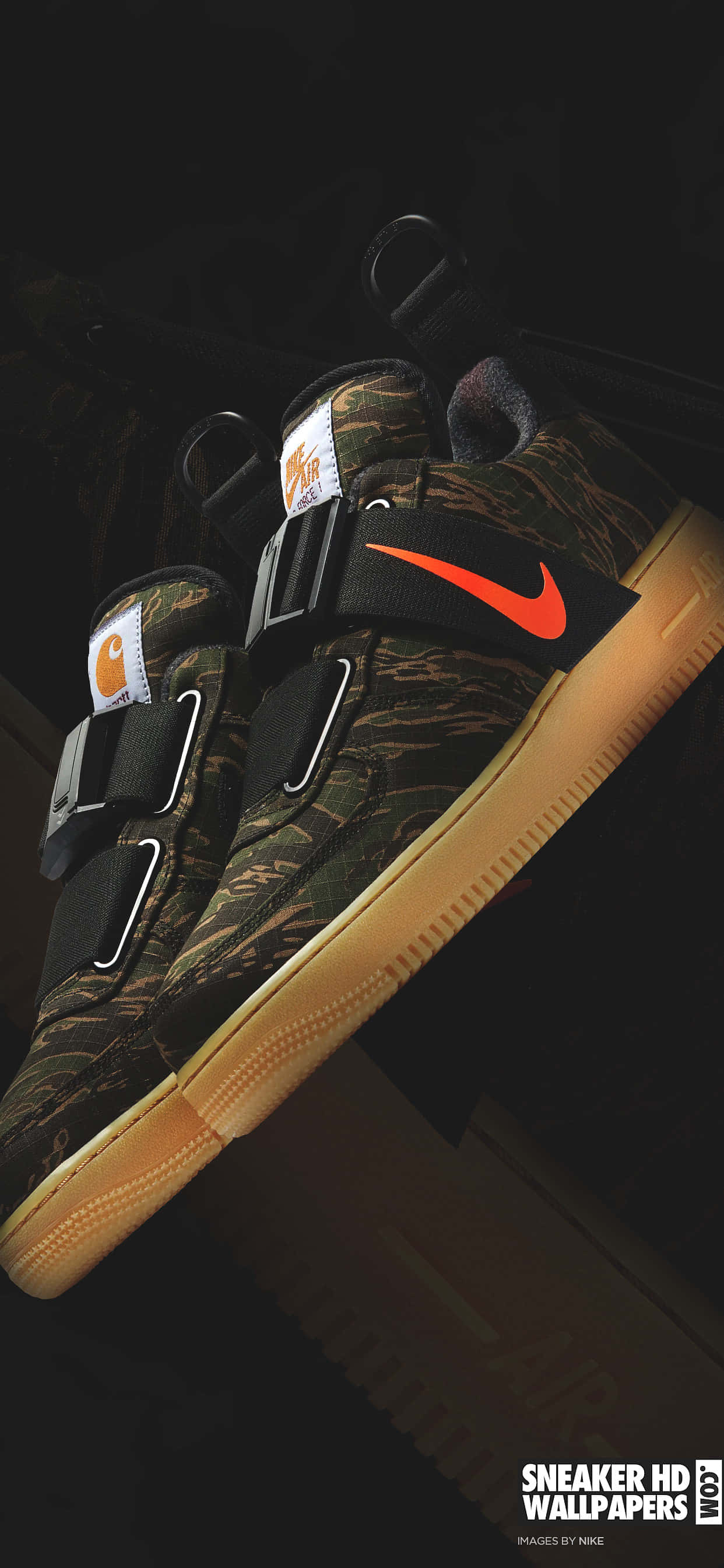 Black Air Force 桌布 壁紙 — 近距離拍攝一雙迷彩Nike運動鞋，帶有橙色Swoosh標誌和棕褐色鞋底，背景為深色。