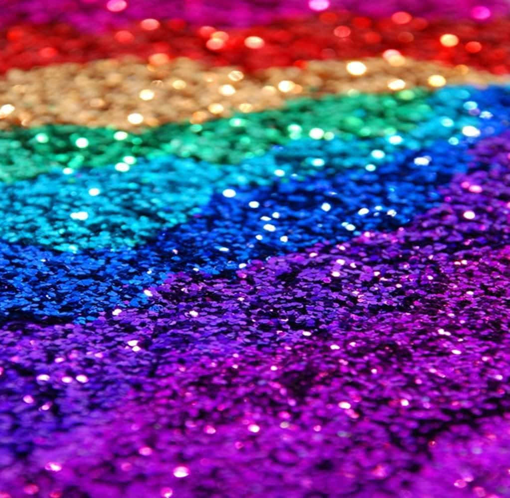 Rainbow Glitter 桌布 壁紙 — 近距離拍攝充滿活力的彩虹亮粉，紅色、橙色、黃色、綠色、藍色和紫色在柔和焦點中閃爍。