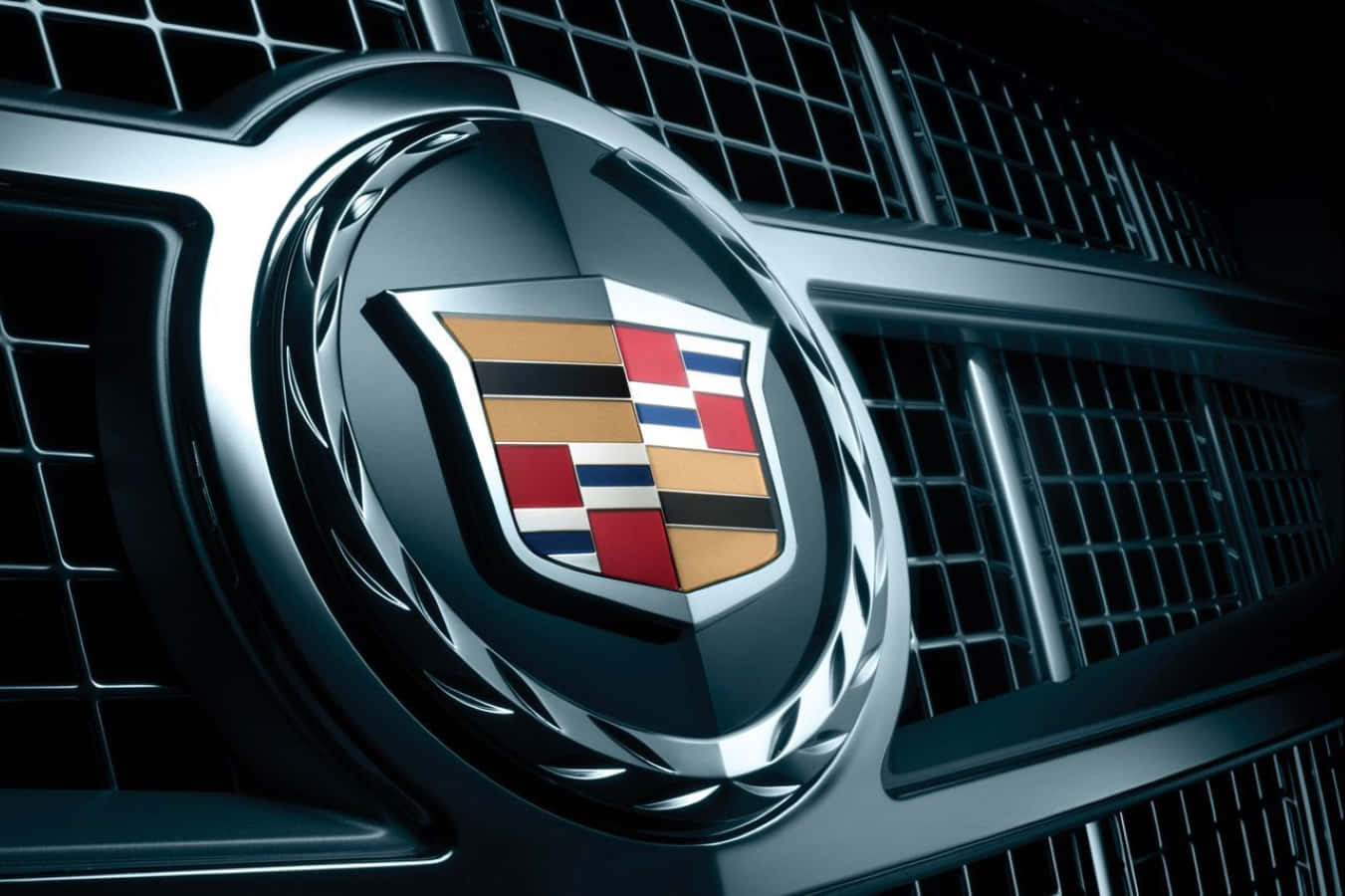 Cadillac Escalade 桌布 壁紙 — 近距離拍攝凱迪拉克標誌在戲劇性燈光下於鍍鉻格柵上閃耀。
