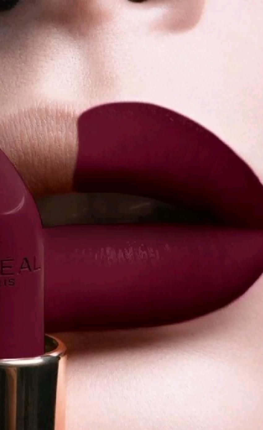 lipstick 桌布 壁紙 — 近距離拍攝塗上濃郁酒紅色唇膏的嘴唇，旁邊放著相配的唇膏管。