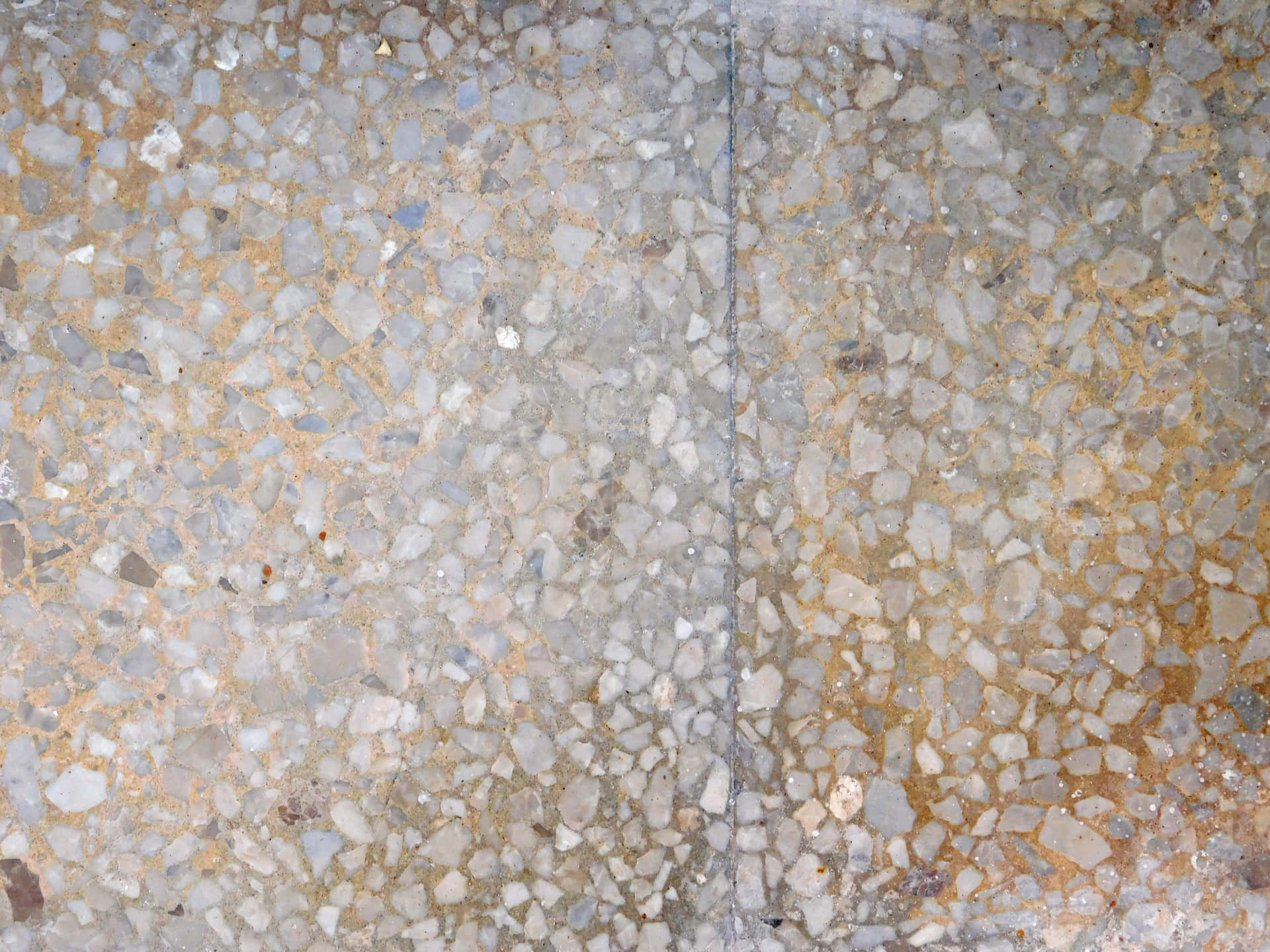 Stone texture 壁紙 — 近距離拍攝帶有斑點的水磨石地板，灰色、白色和棕色的骨料石塊鑲嵌在透明樹脂中。