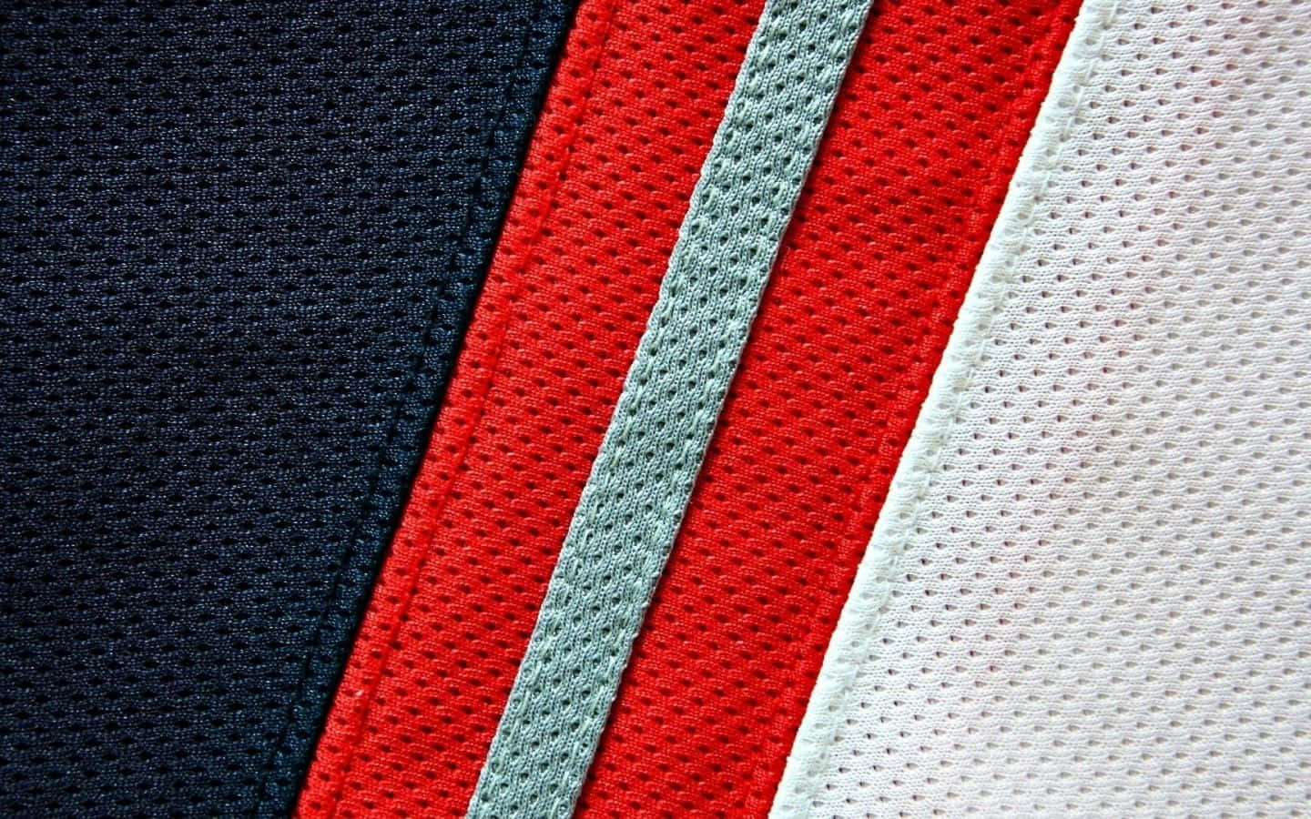 Red White And Blue 桌布 壁紙 — 近距離拍攝帶有海軍藍、紅色、淺灰色和白色斜紋的紋理運動球衣布料。