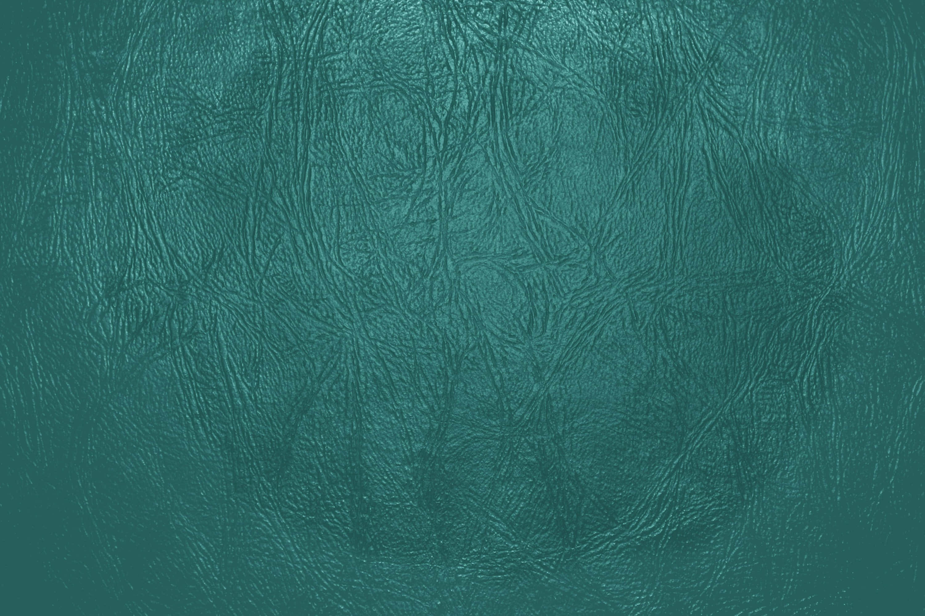 Dark Teal 桌布 壁紙 — 近距離拍攝帶有自然皺褶和柔和漸變燈光的紋理青綠色皮革。