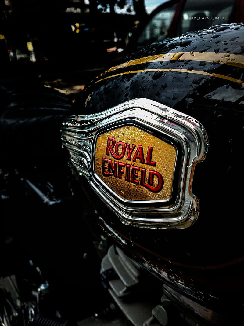 standard 桌布 壁紙 — 近距離拍攝濕漉漉的Royal Enfield機車油箱，鍍鉻徽章在昏暗燈光下反射雨滴。
